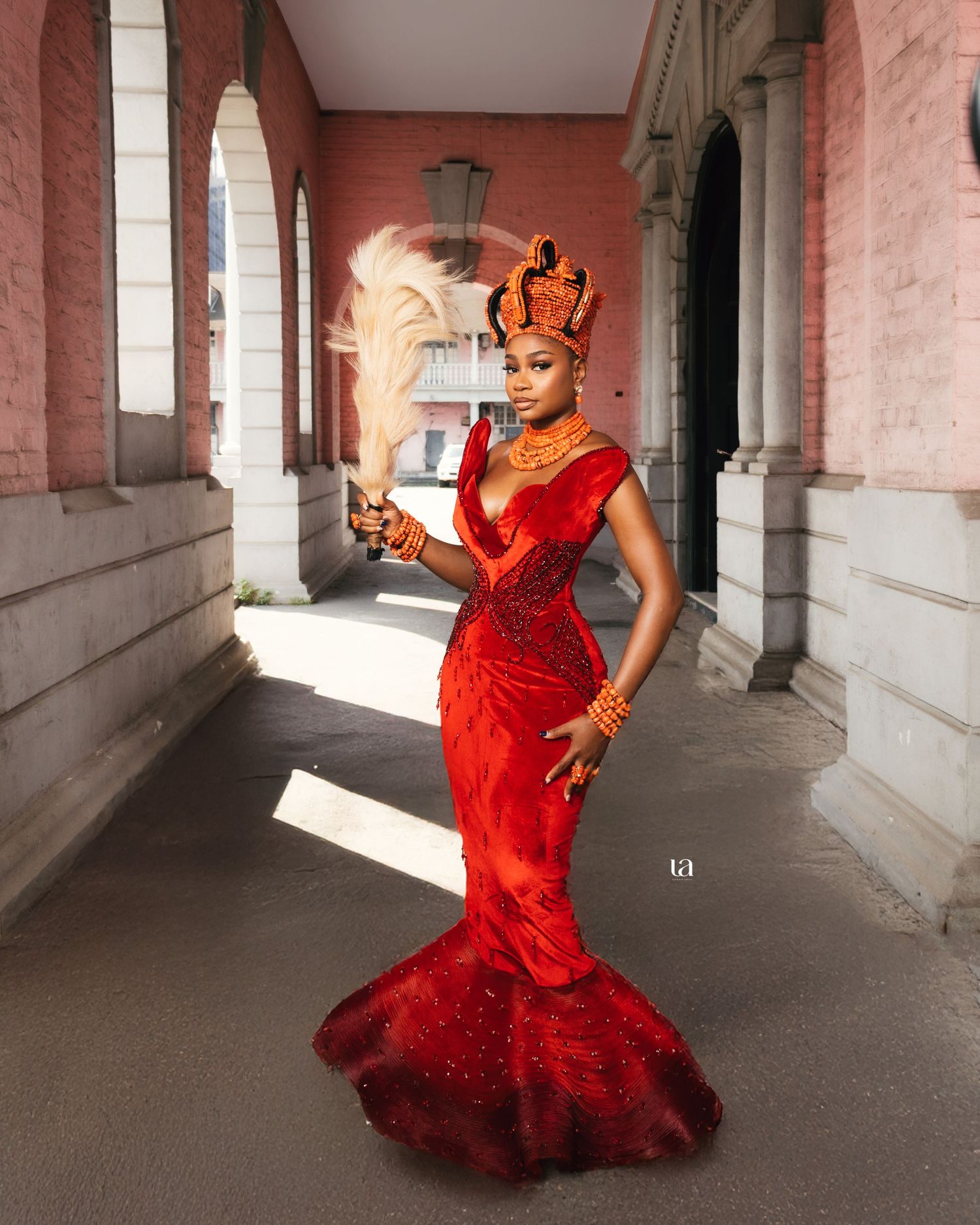 Dramatic red mermaid style dress photographed in historic building with columns.