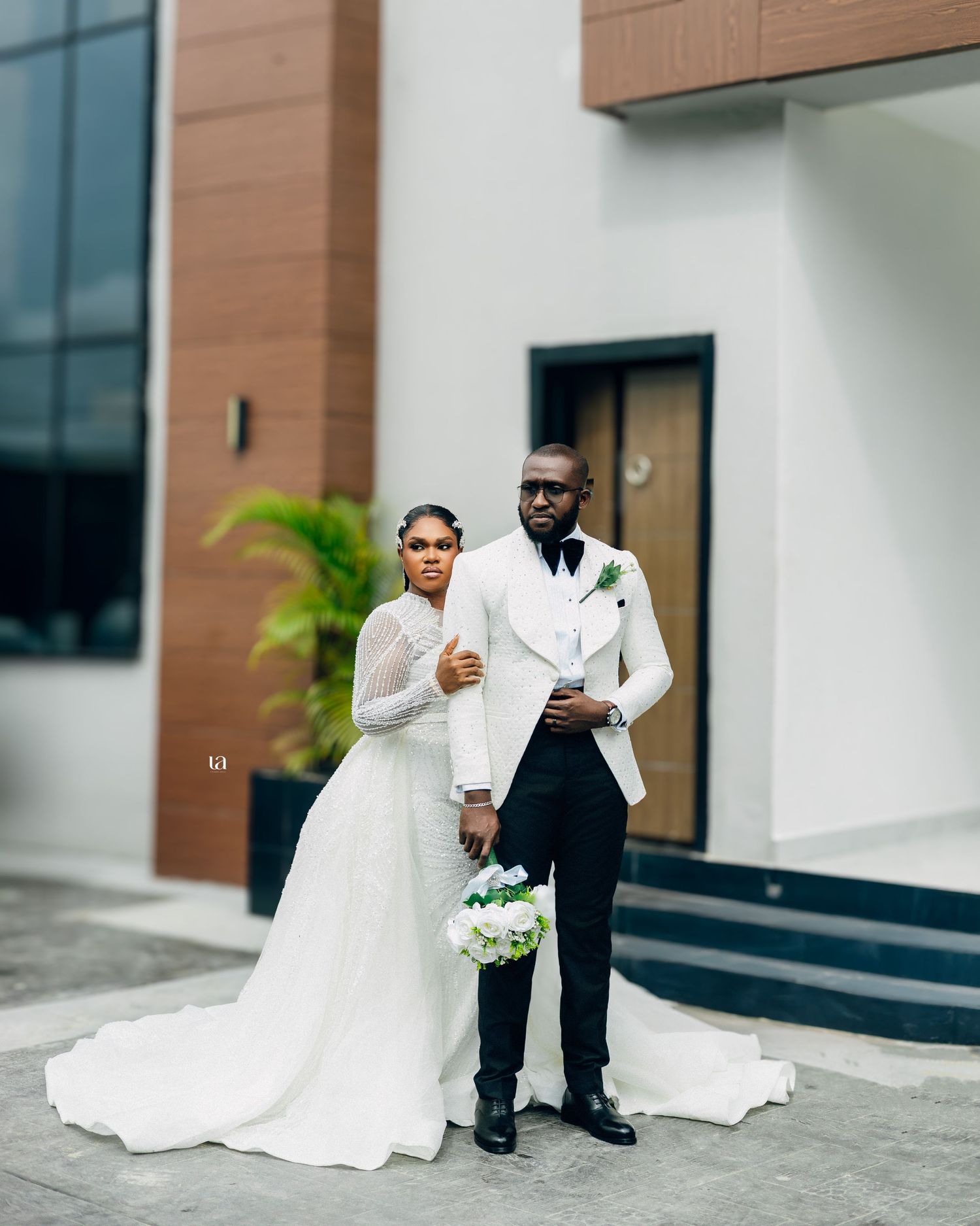 Romantic wedding portrait session outside a modern building with white and wood accents.