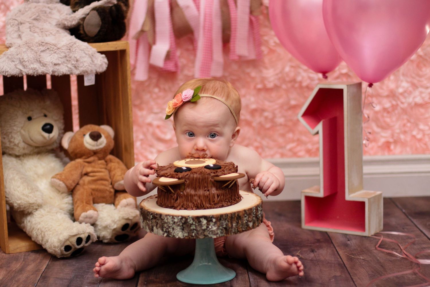Pink-themed first birthday party setup with cake and decorations.