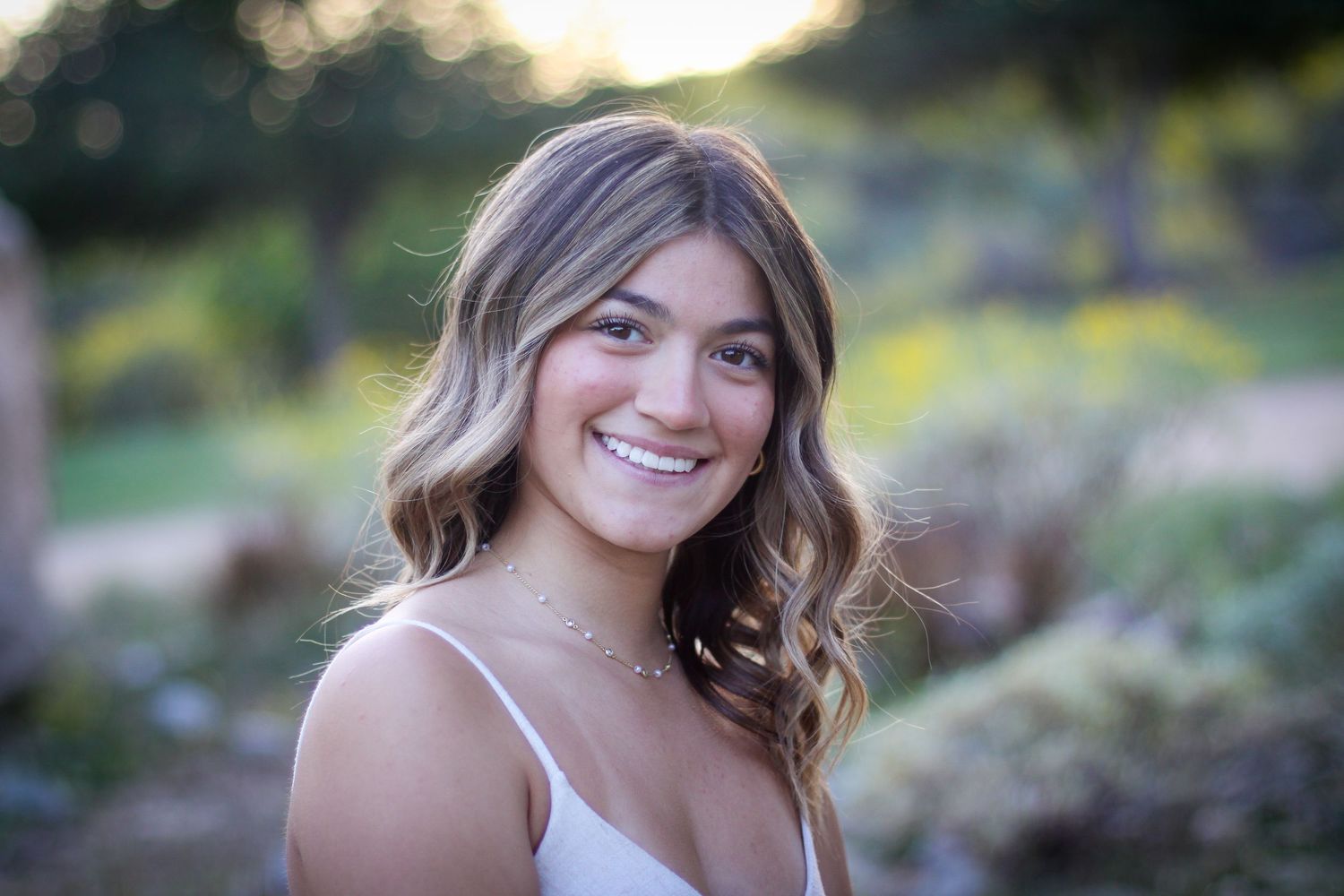 Senior portraits taken in a natural outdoor setting during golden hour.