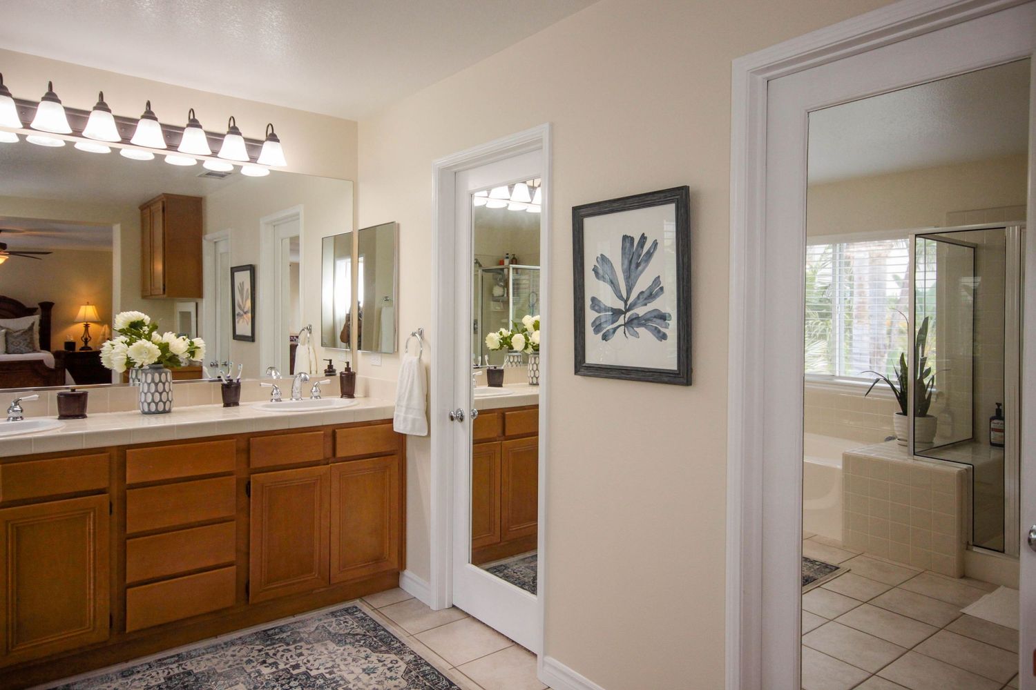 Bright bathroom interior with modern vanity lighting and wooden cabinetry.