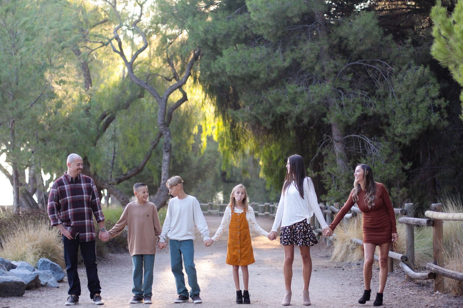 Family members walking together in outdoor setting with natural lighting and trees.