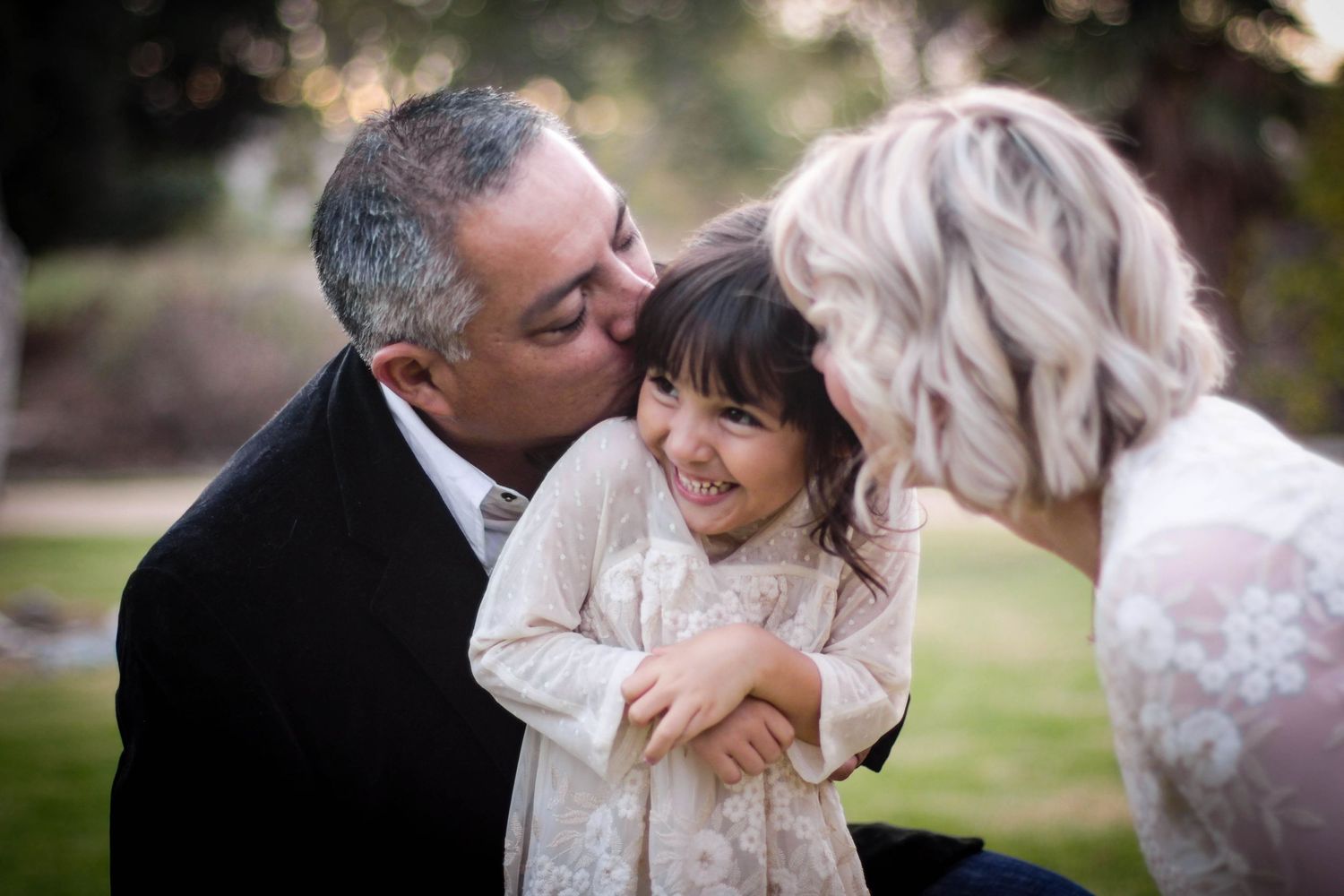 Intimate family moments captured in a series of candid outdoor photos.