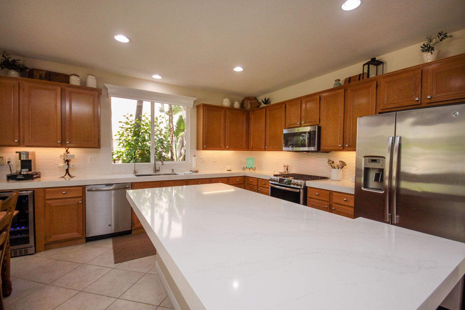 Modern kitchen interior with wood cabinets and white quartz countertops.