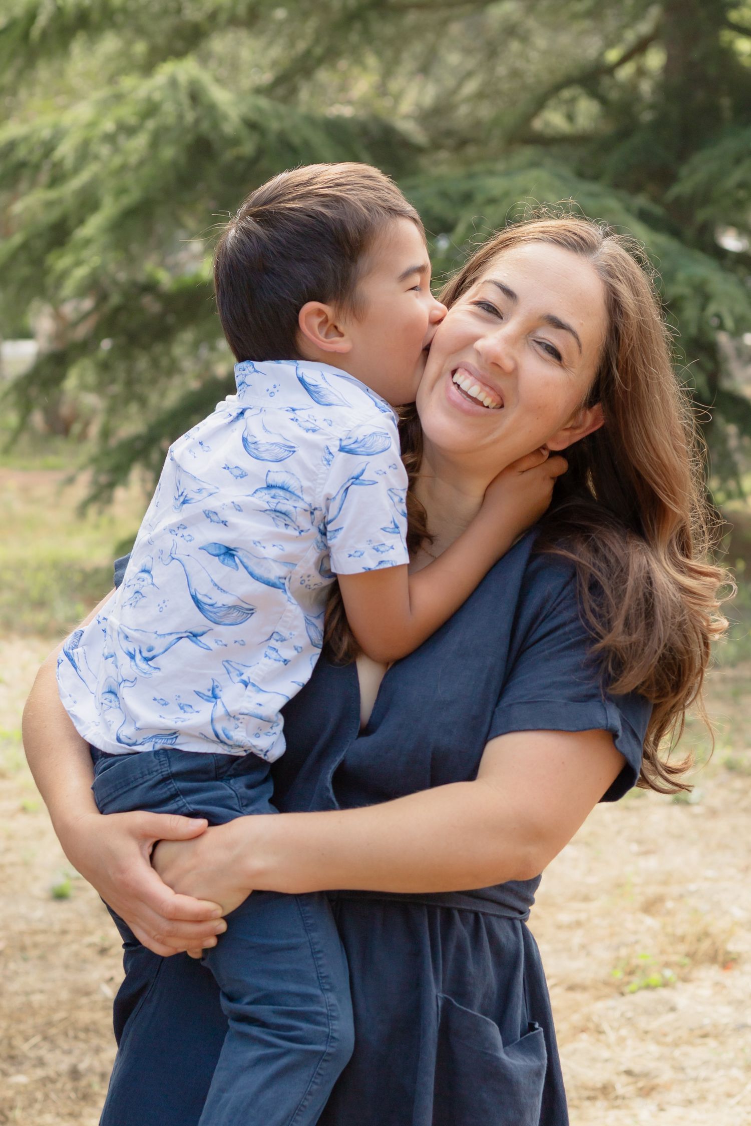 Loving embrace between parent and child in outdoor setting with natural lighting.