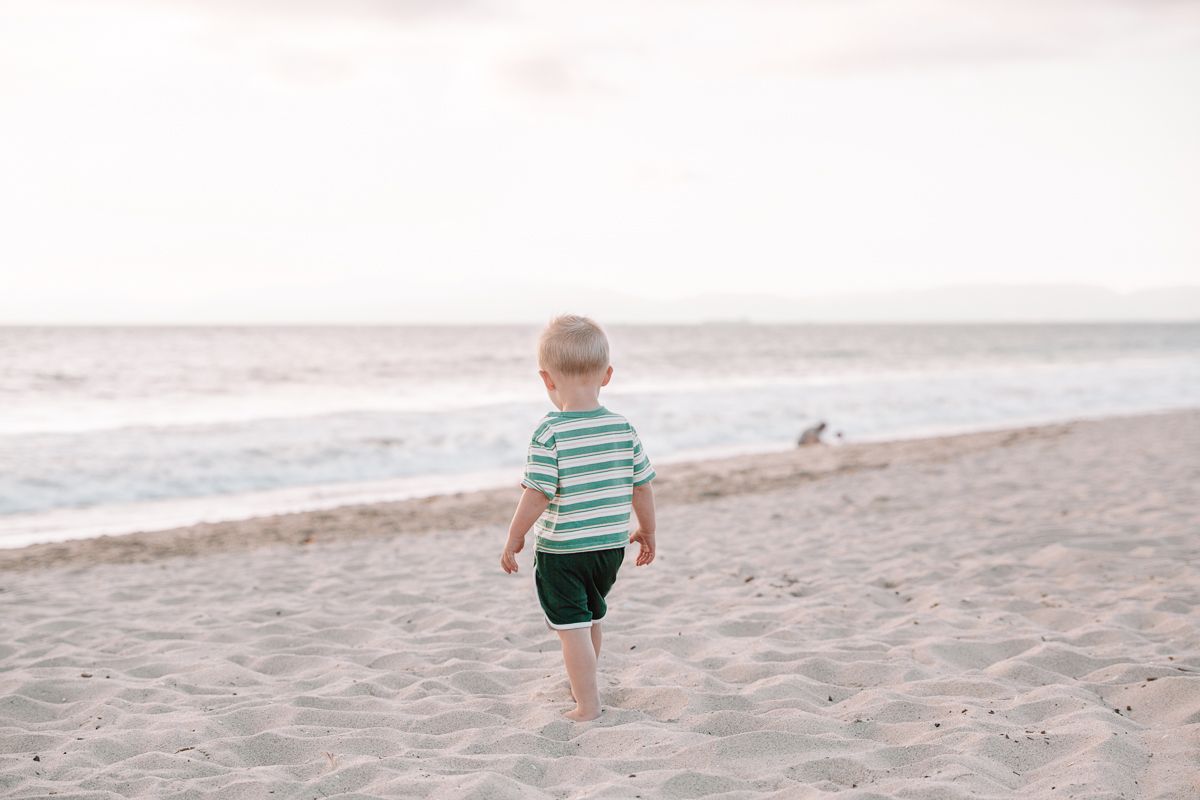 A peaceful beach scene with gentle waves rolling onto the shore under cloudy skies.