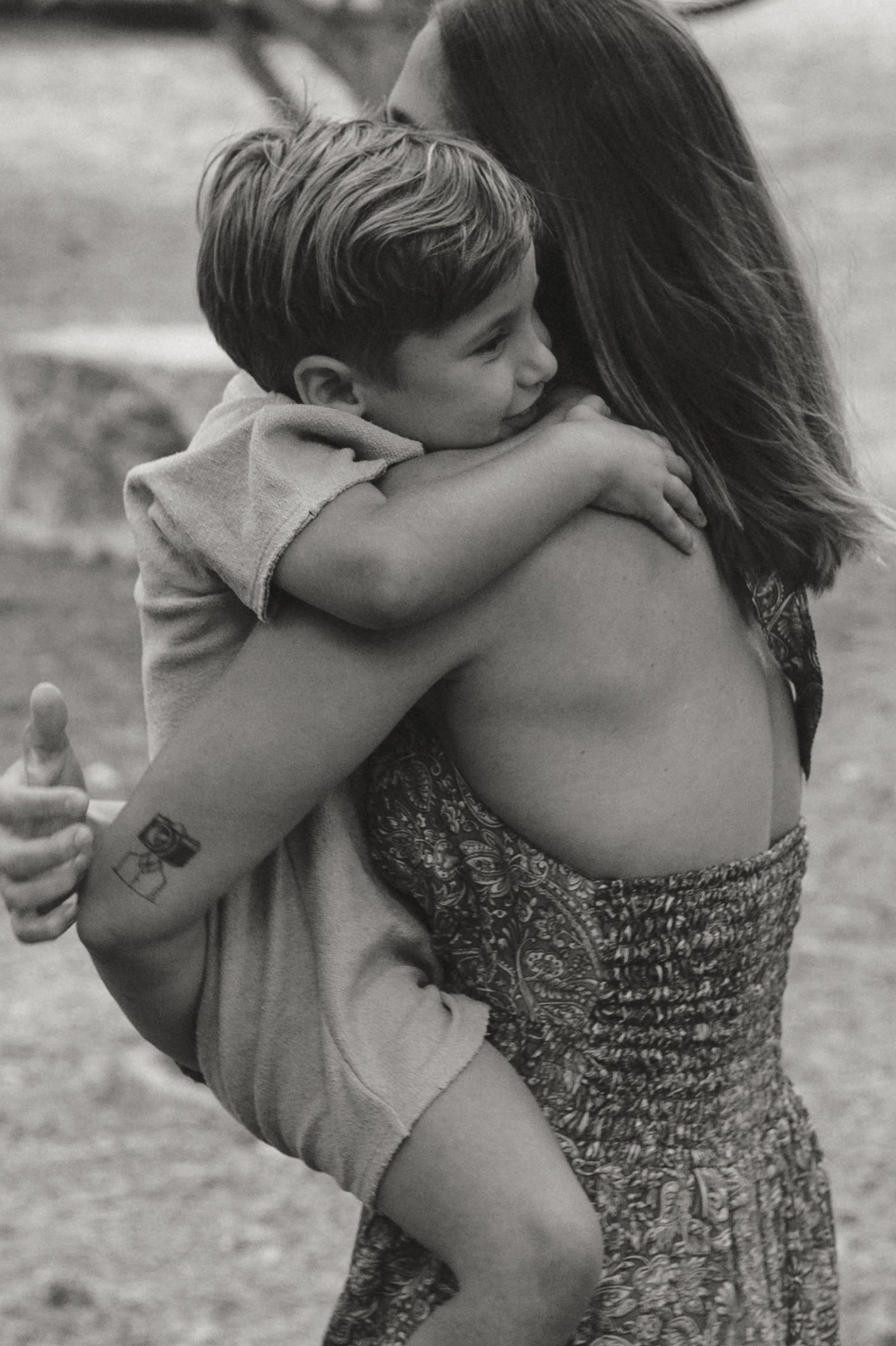 Black and white photo showing intimate family moment outdoors.