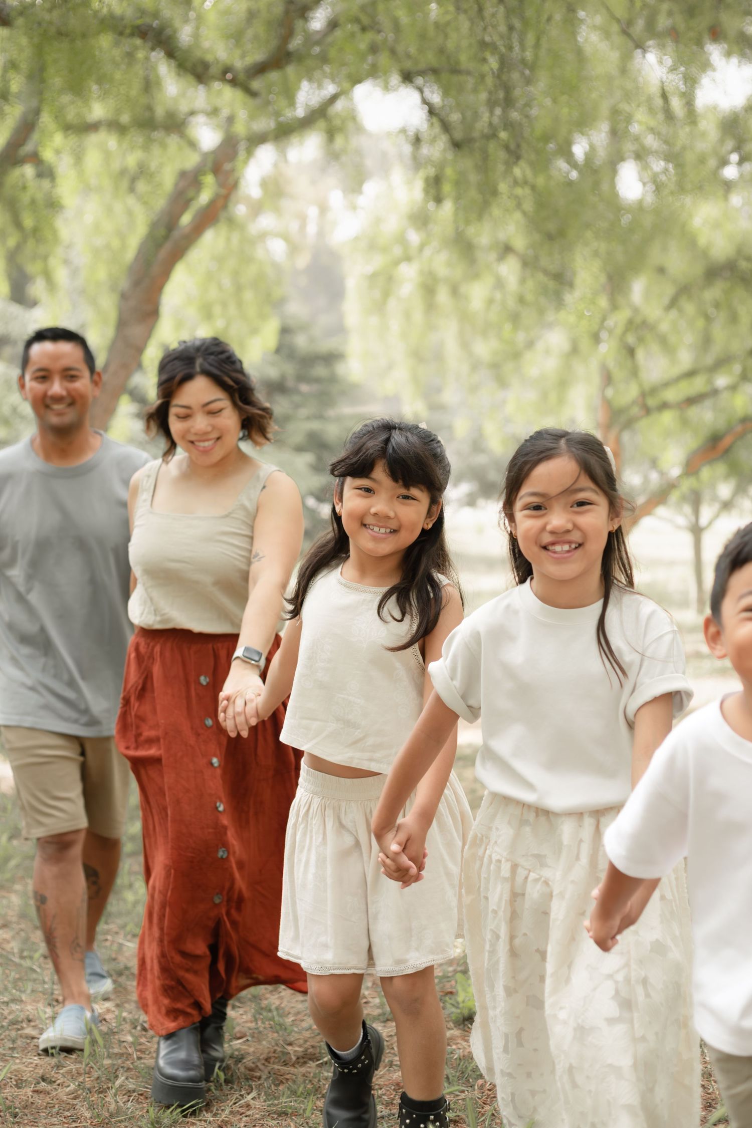 Group of children holding hands and walking together in casual outdoor setting.