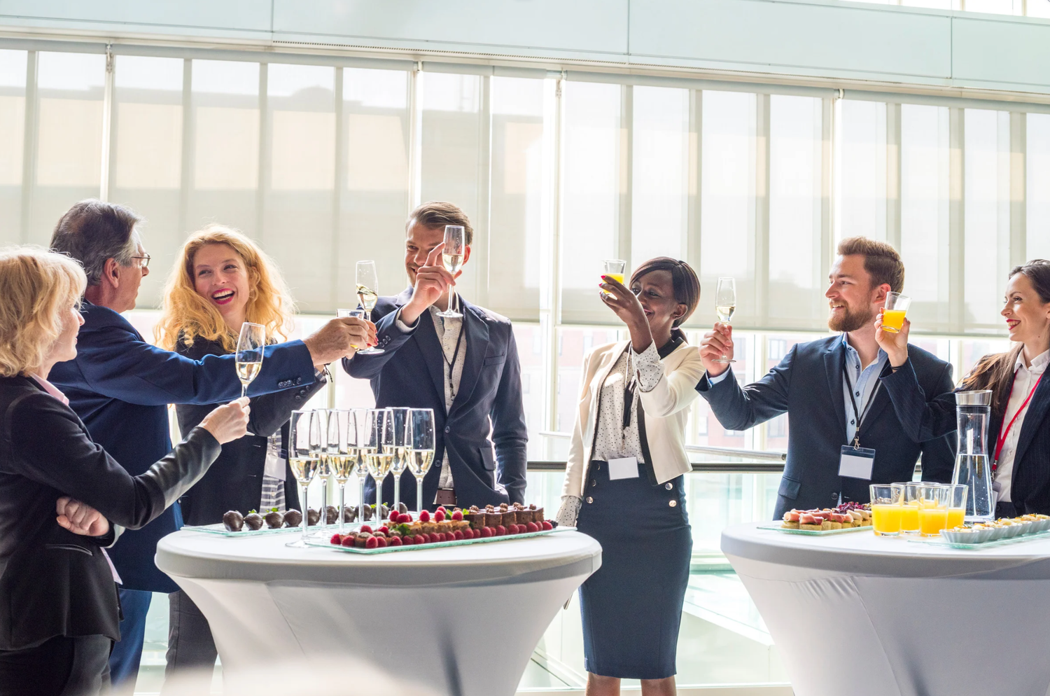 Business professionals toasting with champagne glasses at a corporate networking reception event.