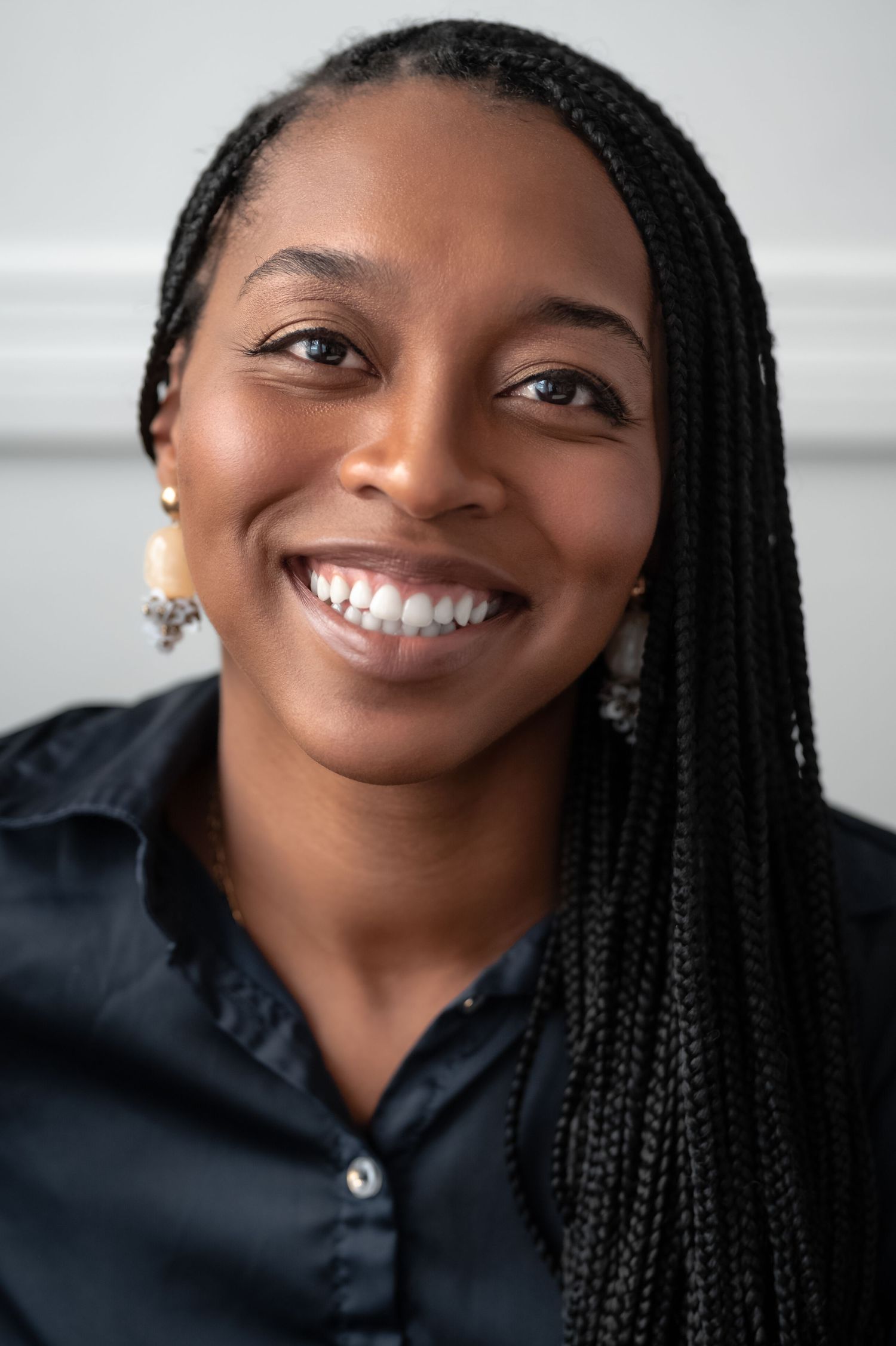 Close-up portrait series showing bright smile and braided hairstyle against white background.