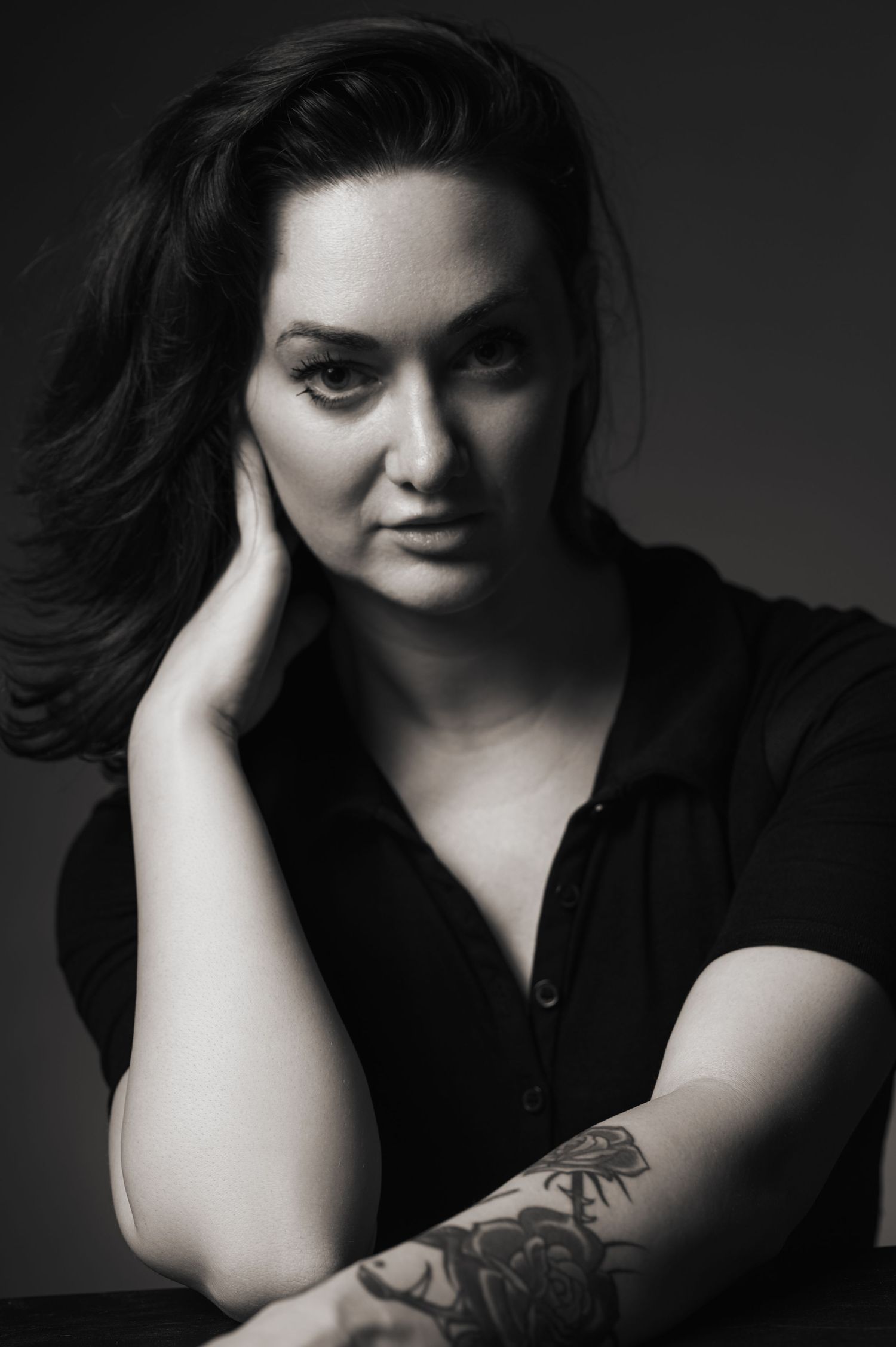 Dramatic black and white portrait series showing artistic poses against dark background.