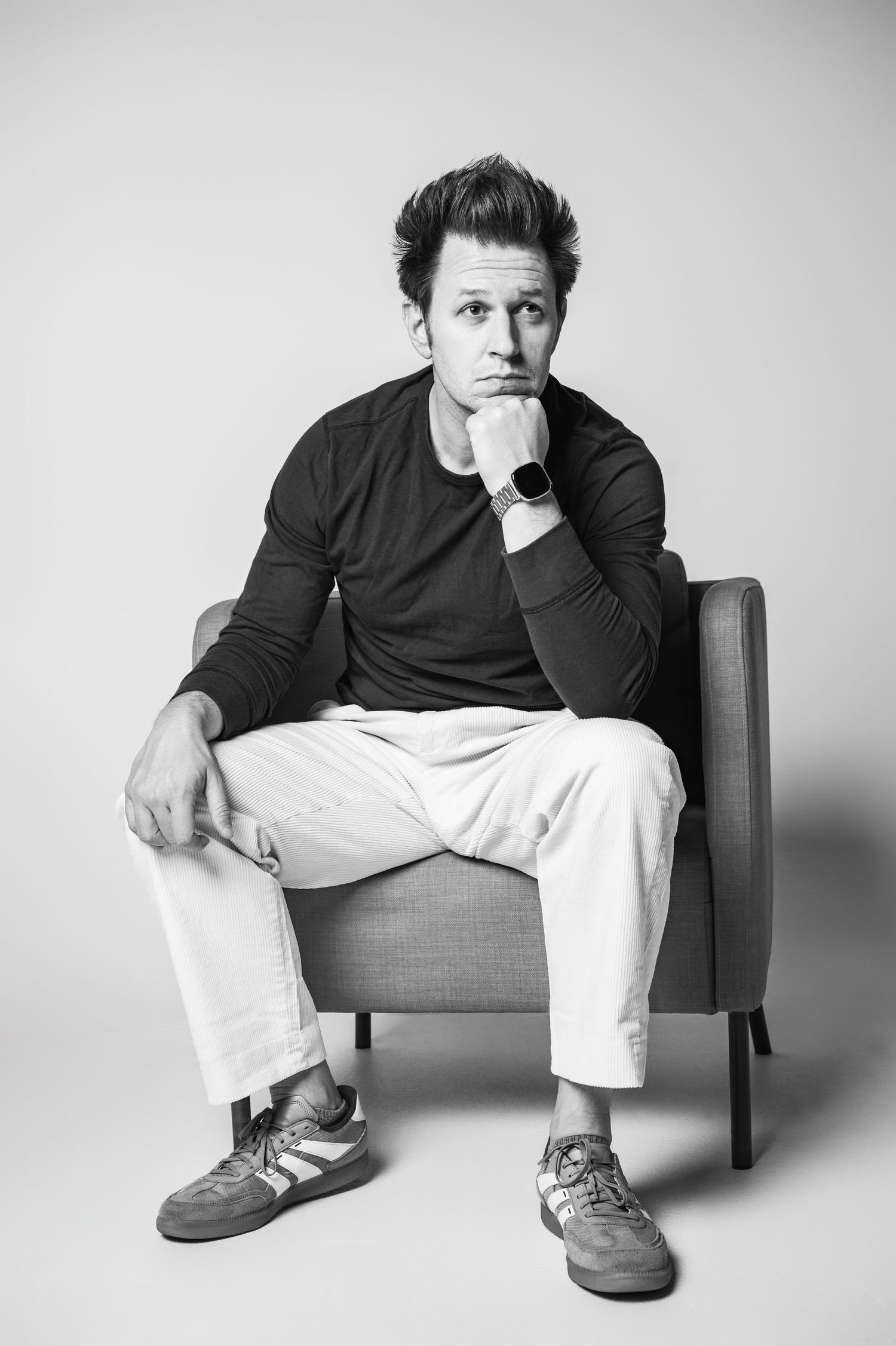 Black and white portrait series showing person lounging thoughtfully in chair wearing dark sweater.