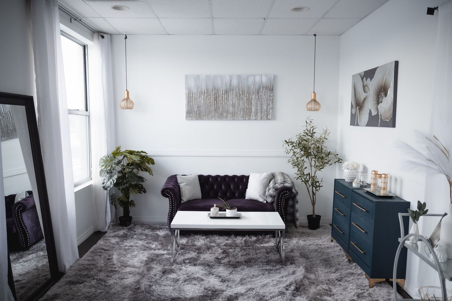 Modern minimalist bedroom design features white walls, grey accents, and natural light from large windows.