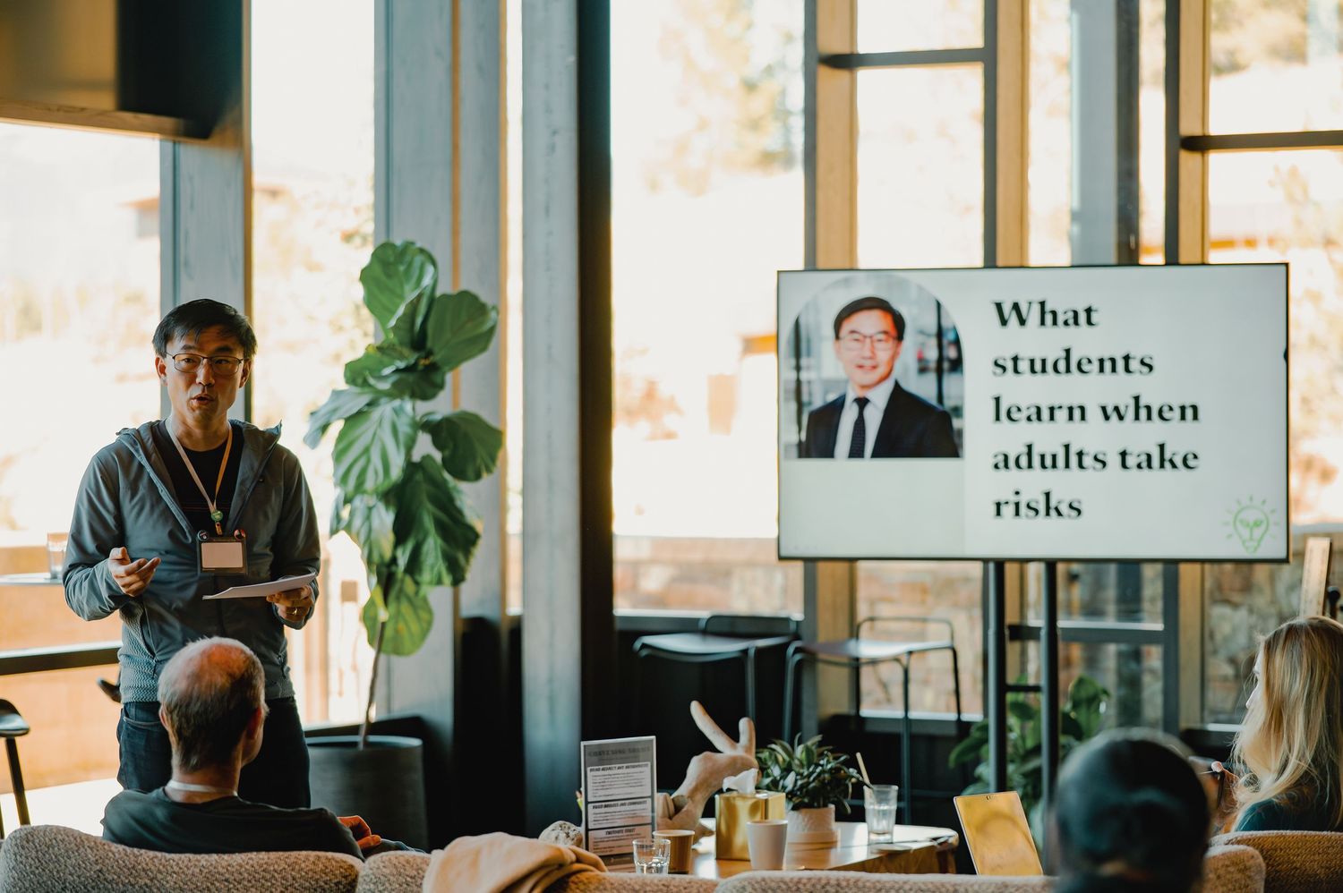 Speaker presenting a slide titled What Students Learn When Adults Take Risks at an indoor educational conference.