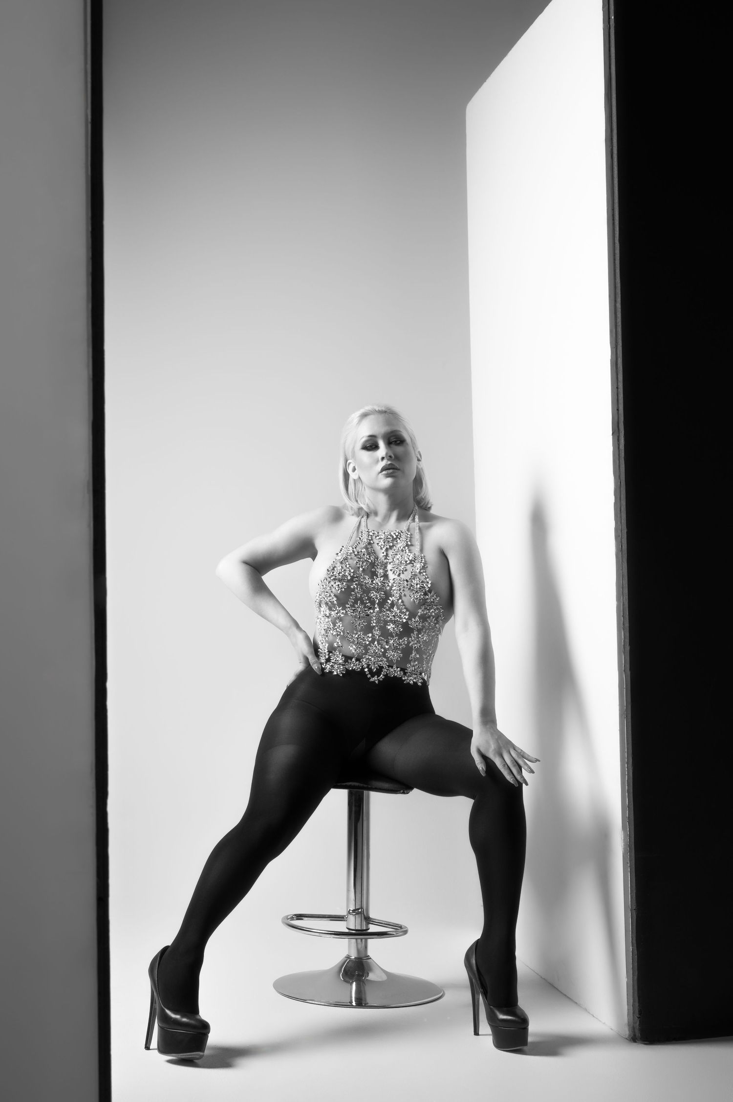 Black and white fashion photo series showing a model in black pants posing dynamically against a white backdrop.