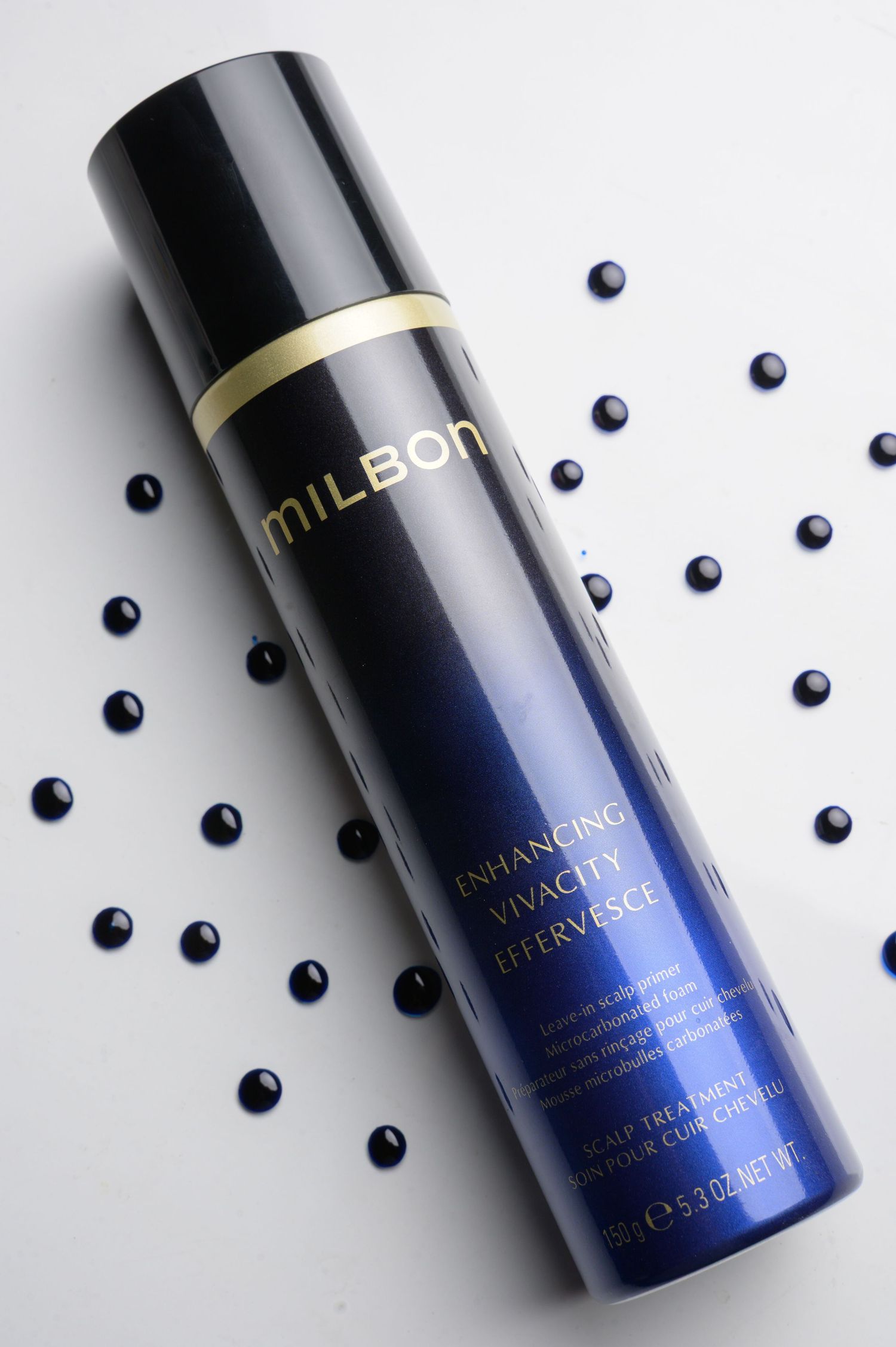 Sleek navy blue cosmetic bottles with scattered blueberries on white background in minimalist product photography.
