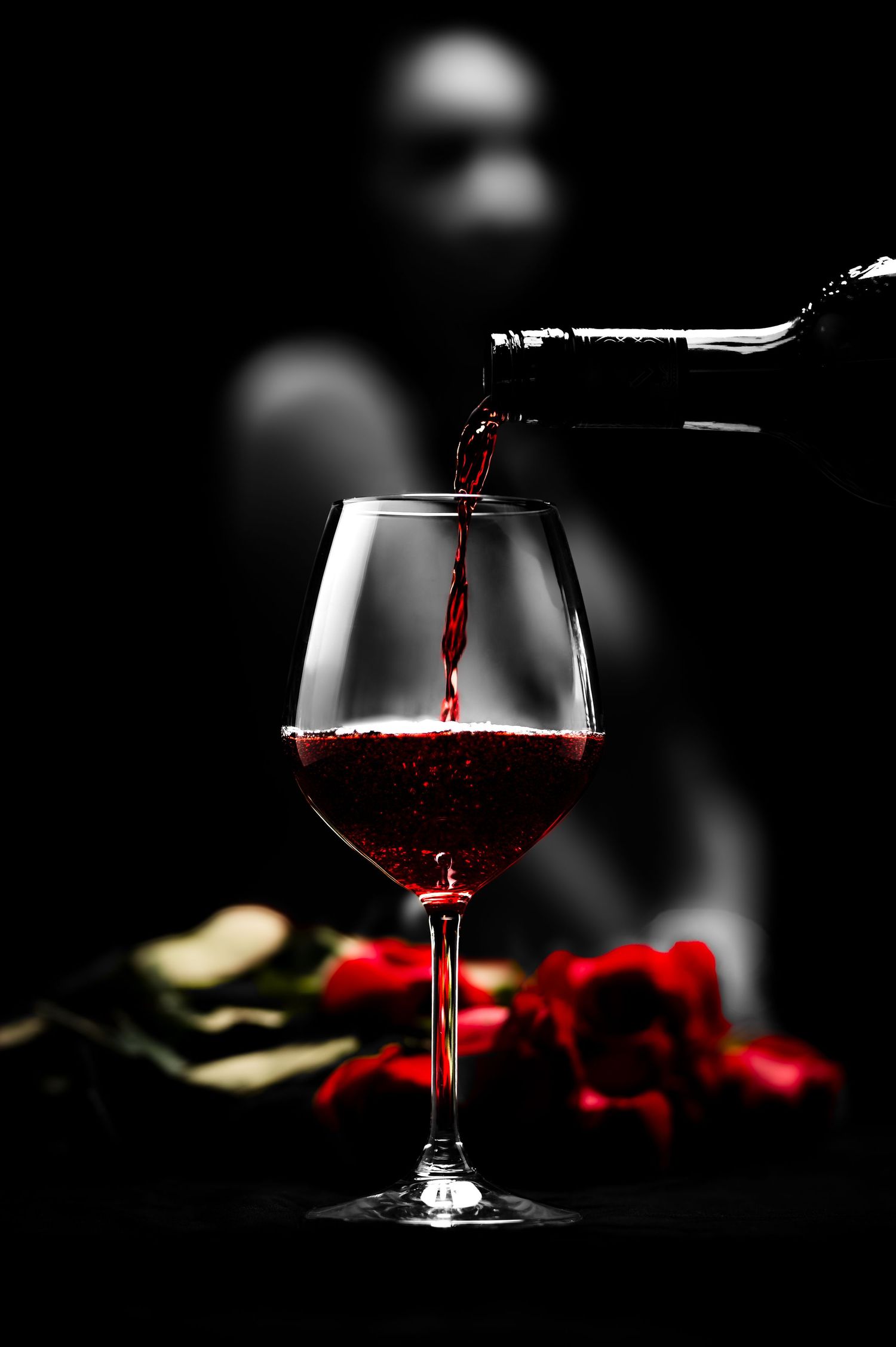 Artistic sequence of red wine glasses in dark lighting with dramatic shadows and reflections against black backgrounds.