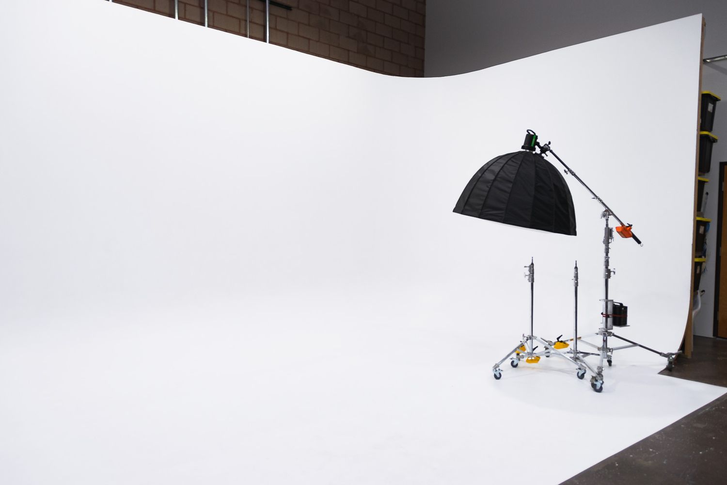 Professional photography studio setup with white backdrop, lighting equipment and reflectors arranged for a shoot.