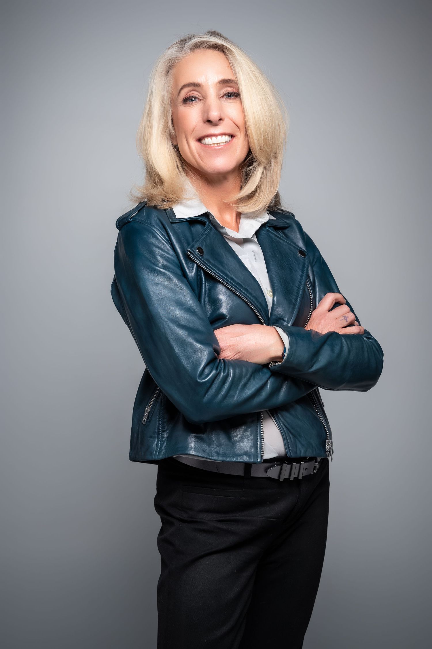 Dynamic poses in black leather jacket against gray studio background.