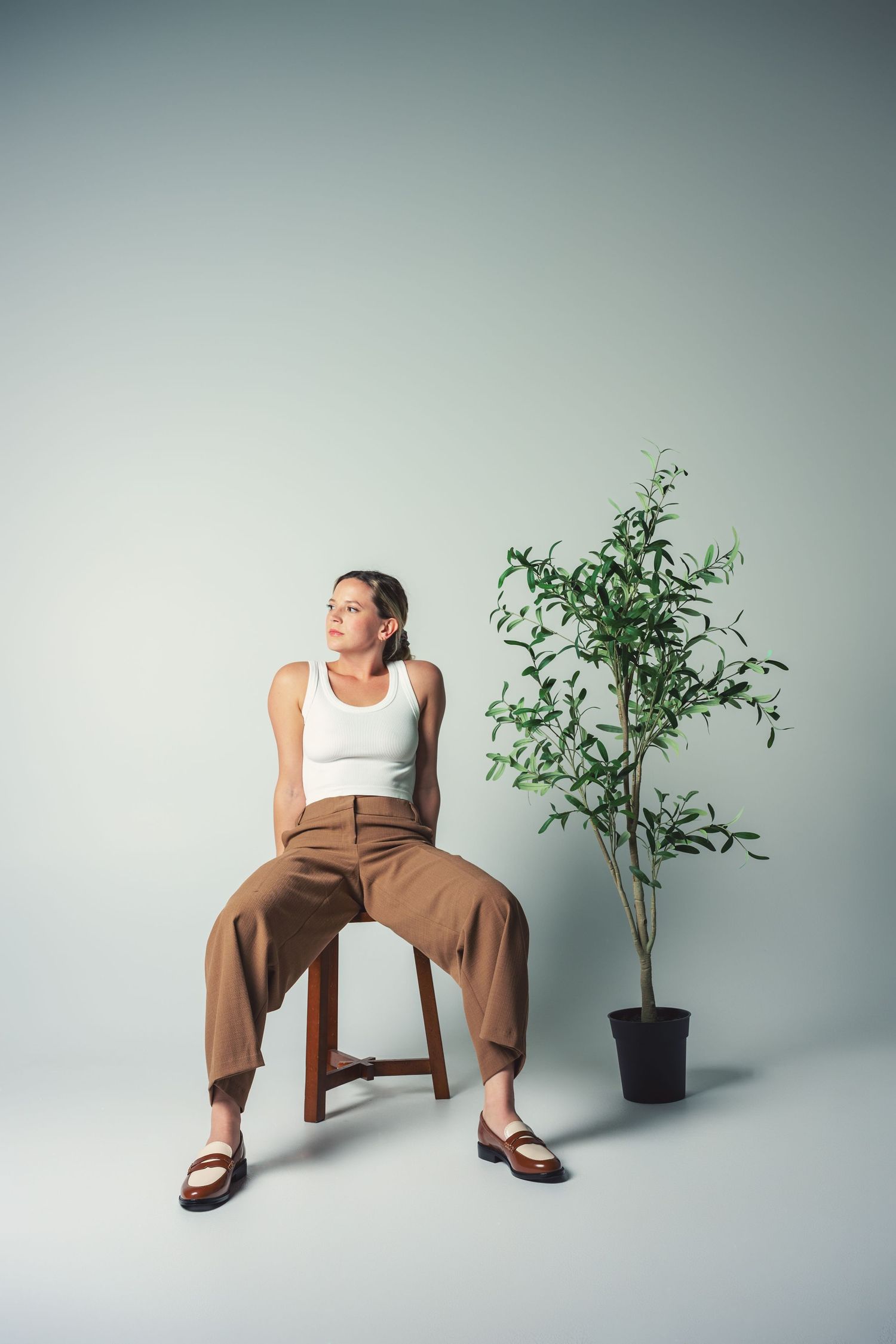 Minimalist photo series of person in tan pants and white top posing with potted plant.