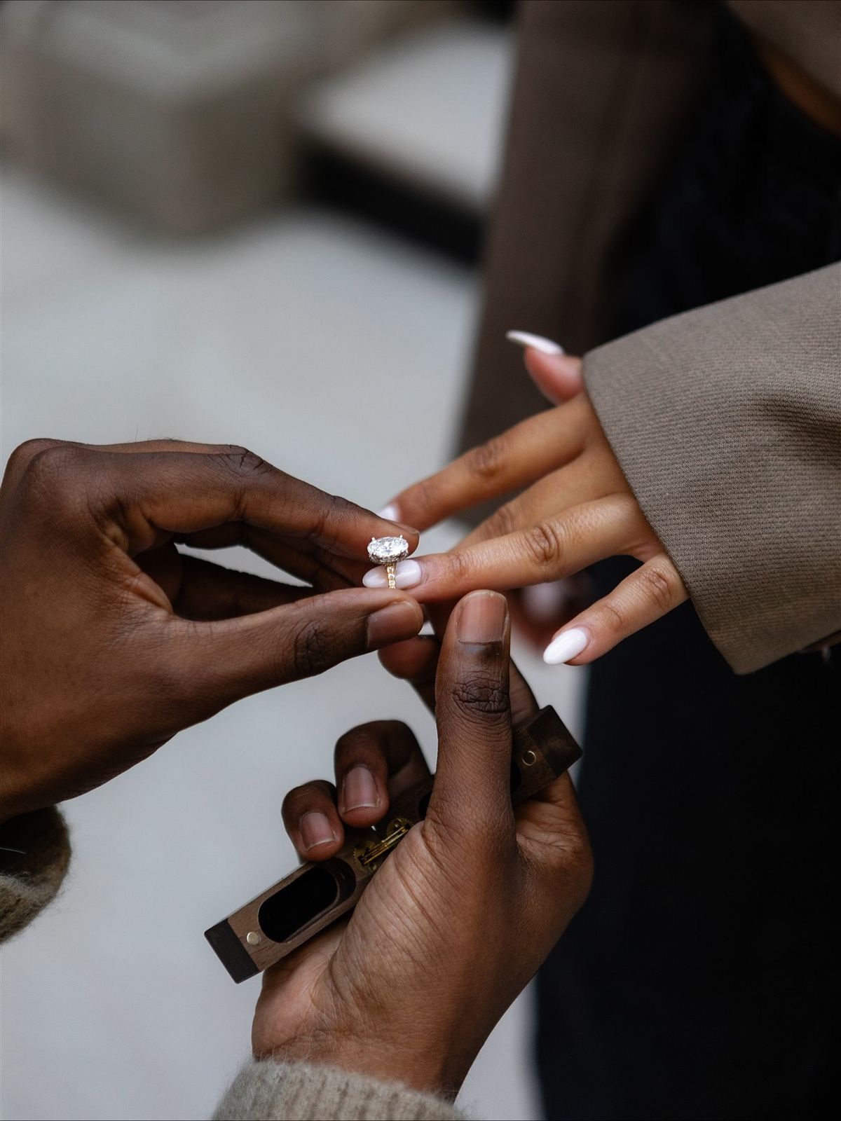 Close-up sequence of hands exchanging a ring during an intimate wedding ceremony moment.