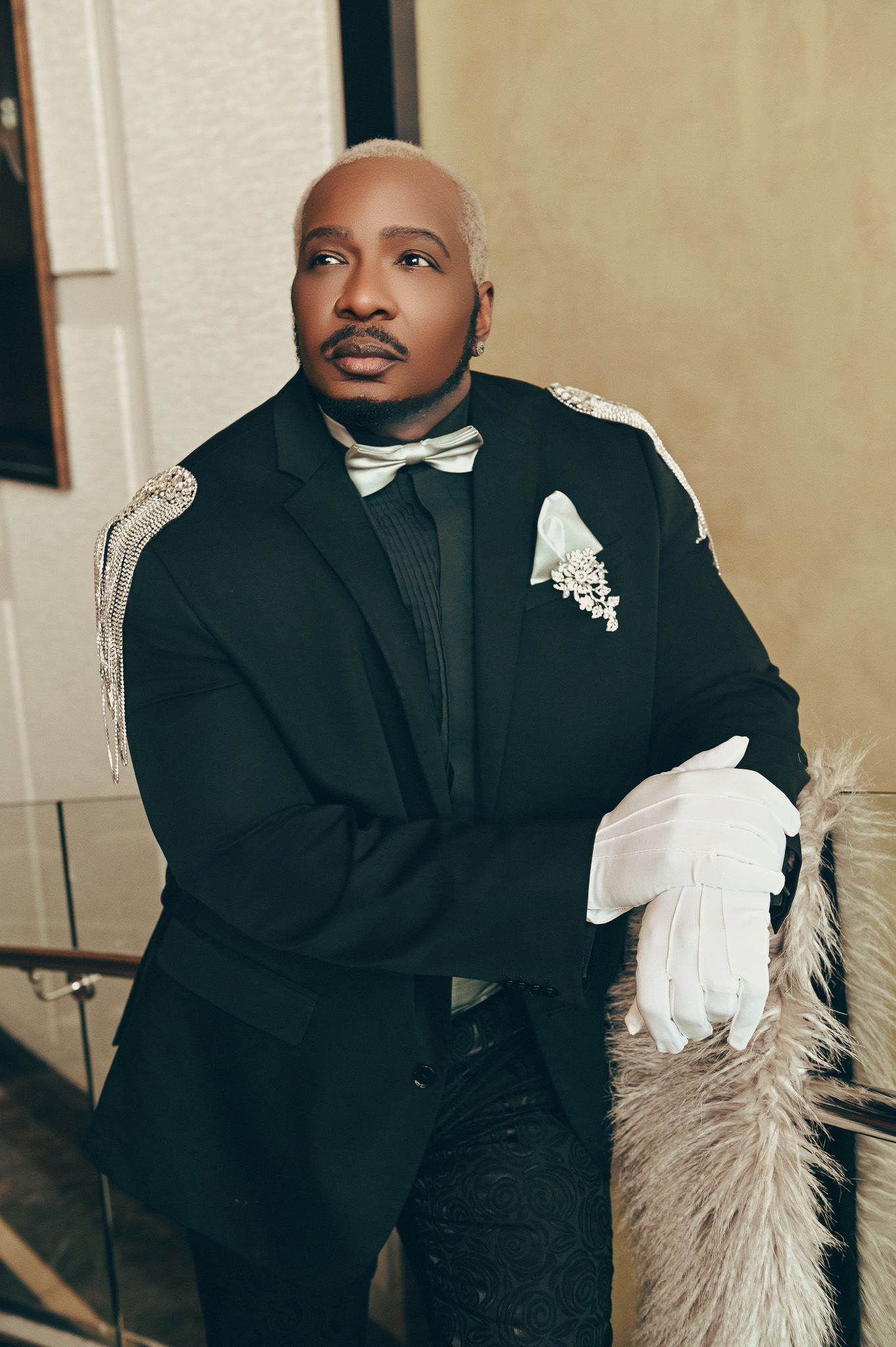 A classic black and white tuxedo ensemble with bow tie in formal portraiture.