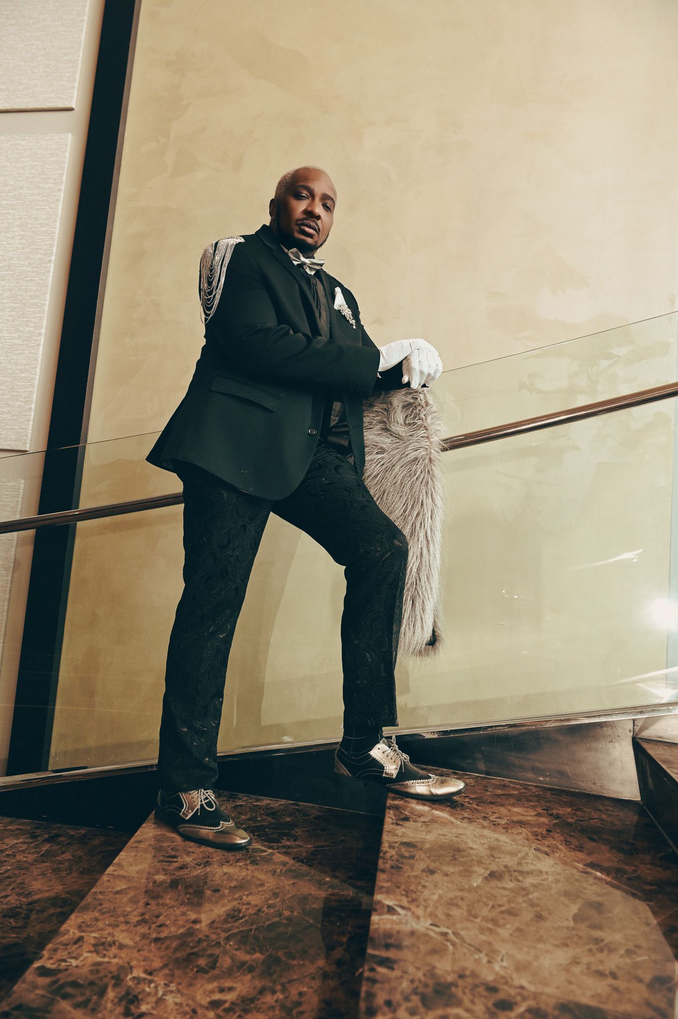 A formal black suit is captured in dynamic poses against a light background.
