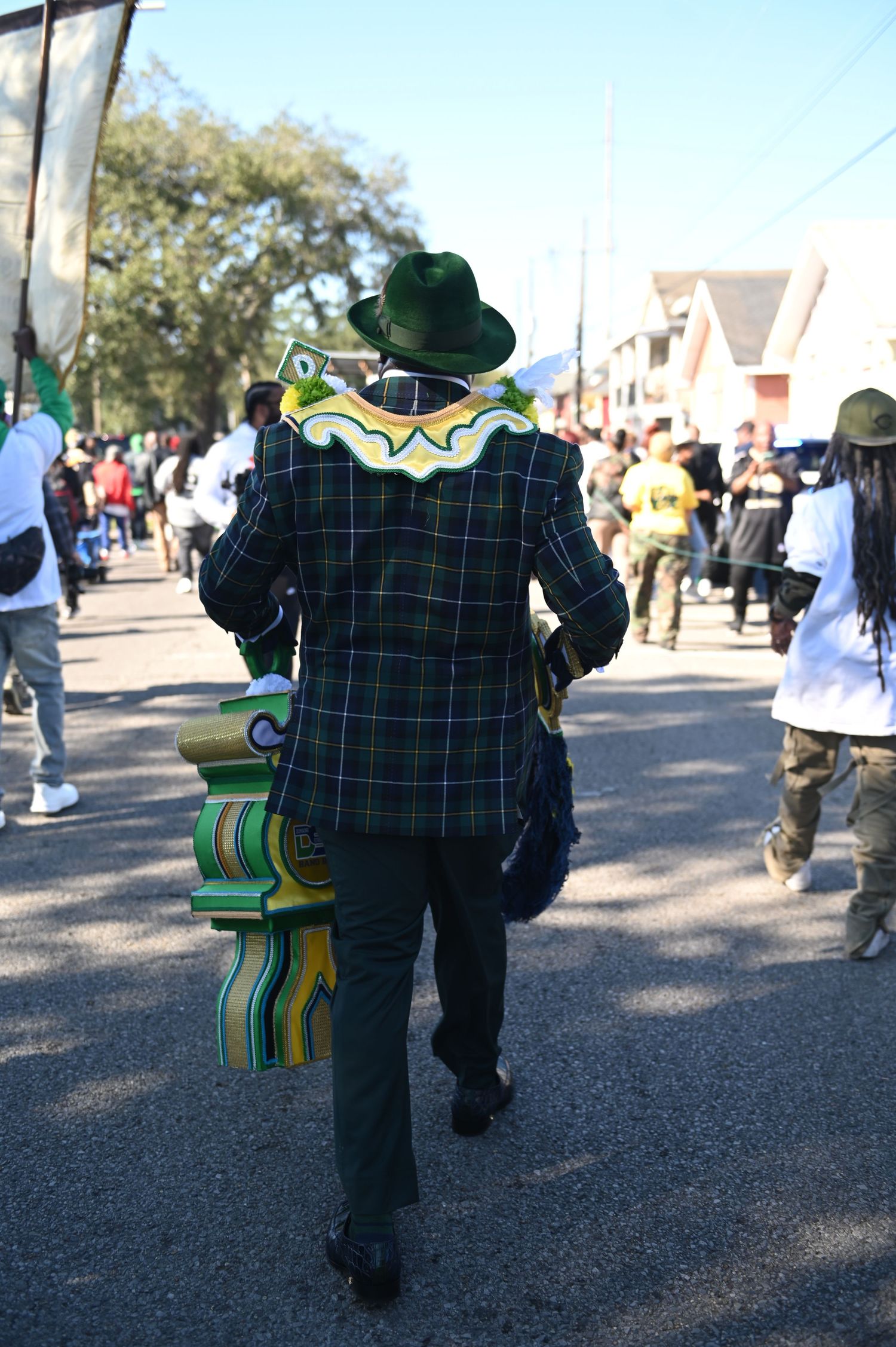 A series of photos showing someone in a green plaid shirt and black pants walking away on a sunny day.