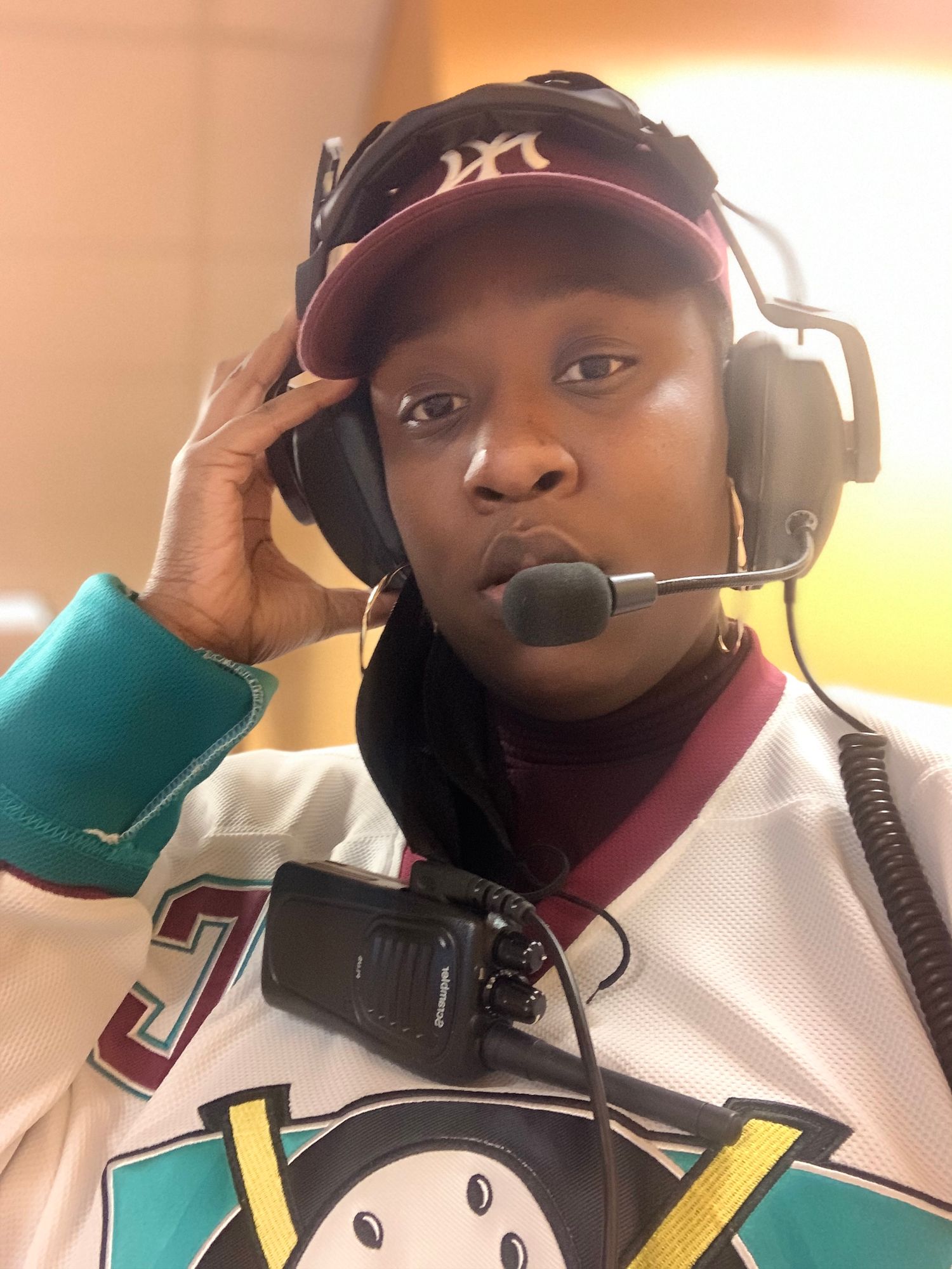 A broadcast professional wearing headphones and microphone while working.