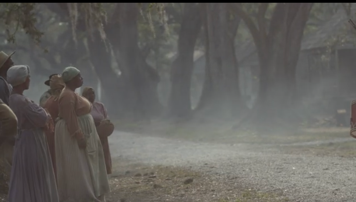 A misty forest scene with figures standing in period dress.