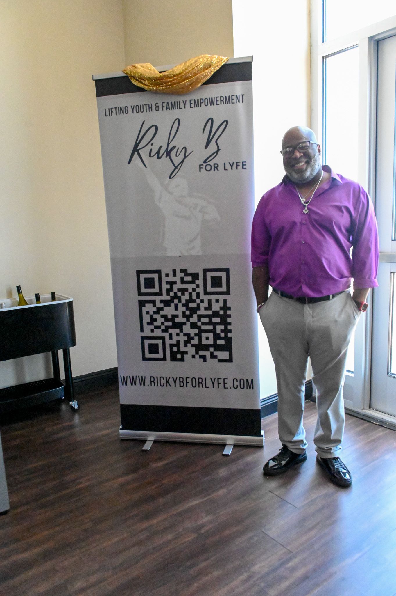 An indoor business setting with QR codes and banners displayed on hardwood floors.