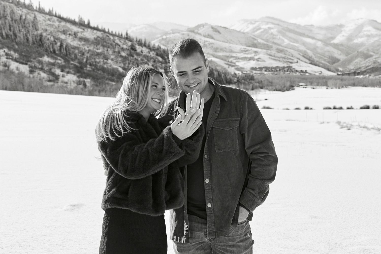 Two people share an emotional moment in a snow-covered mountain landscape.