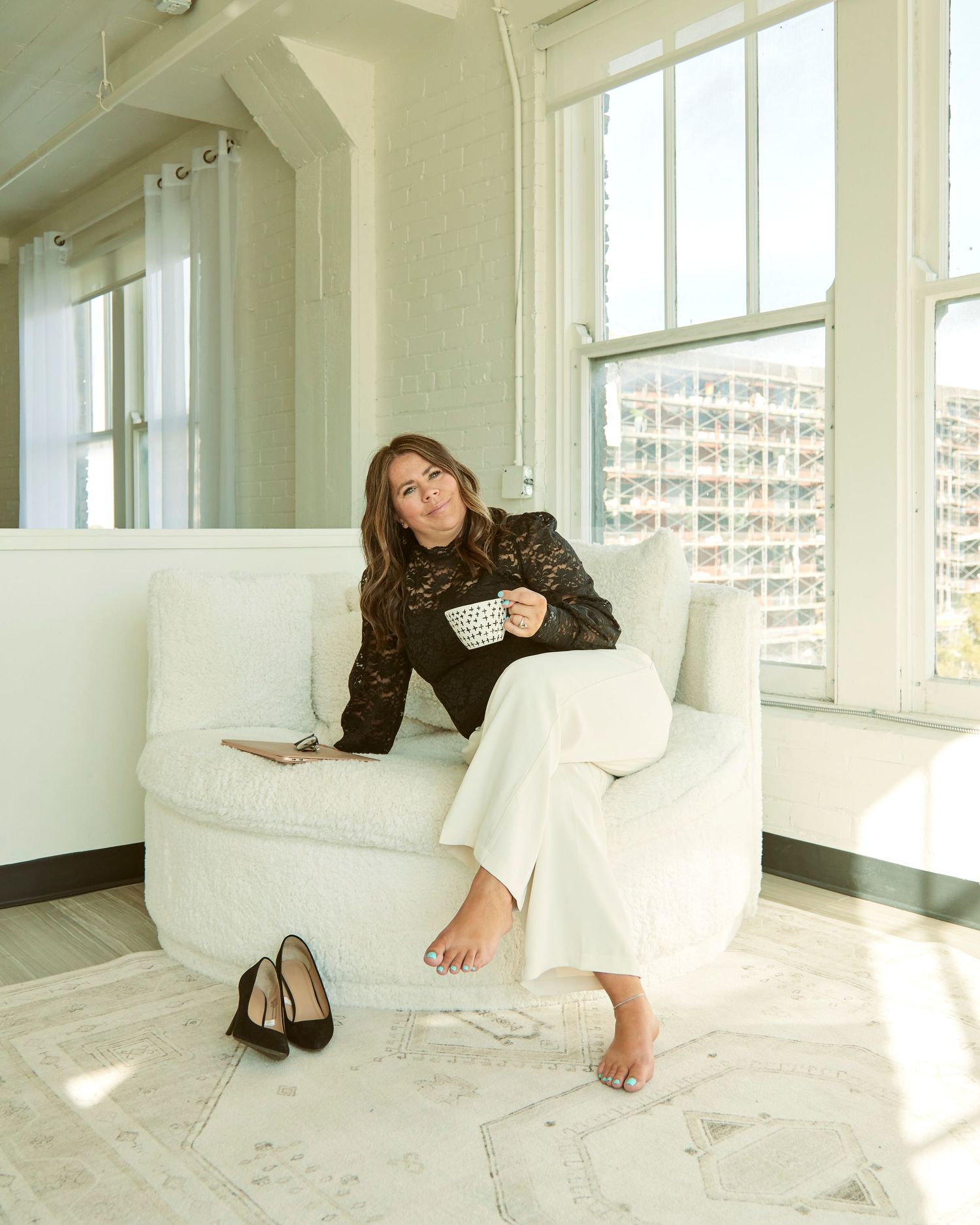 Casual lifestyle photo in sunlit room with white couch and high windows.