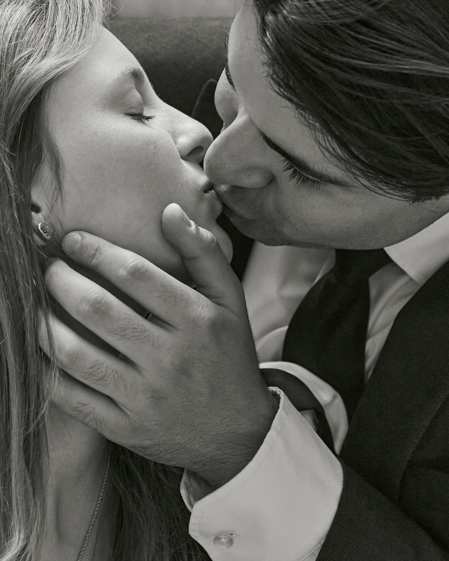 An intimate black and white portrait of a romantic kiss.