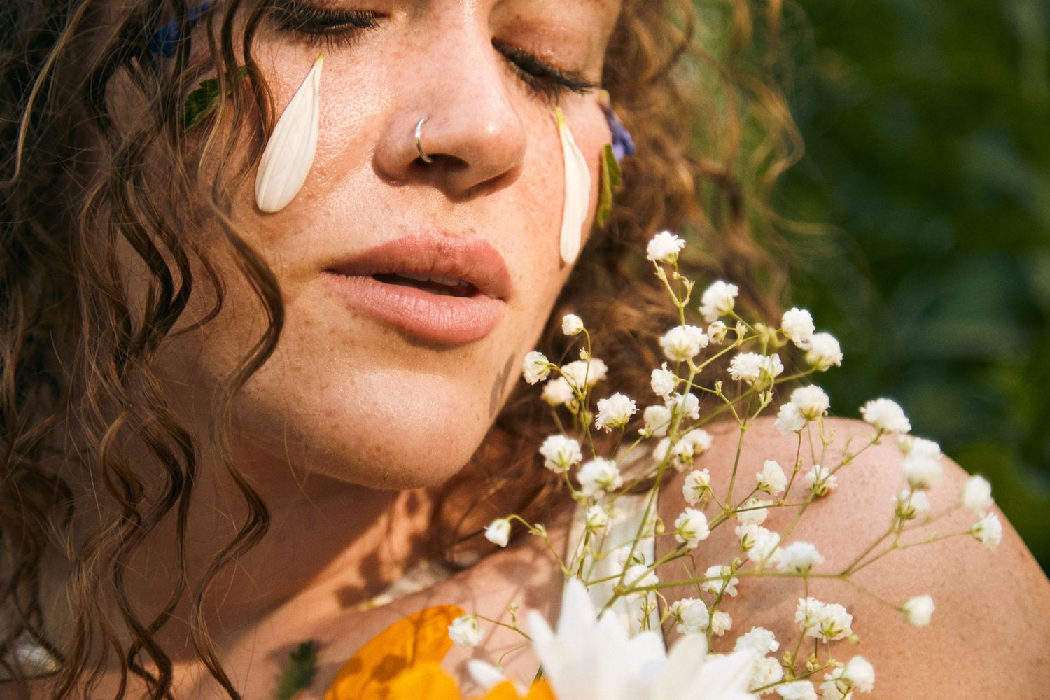 Close-up portrait with delicate white flowers and yellow face paint markings.