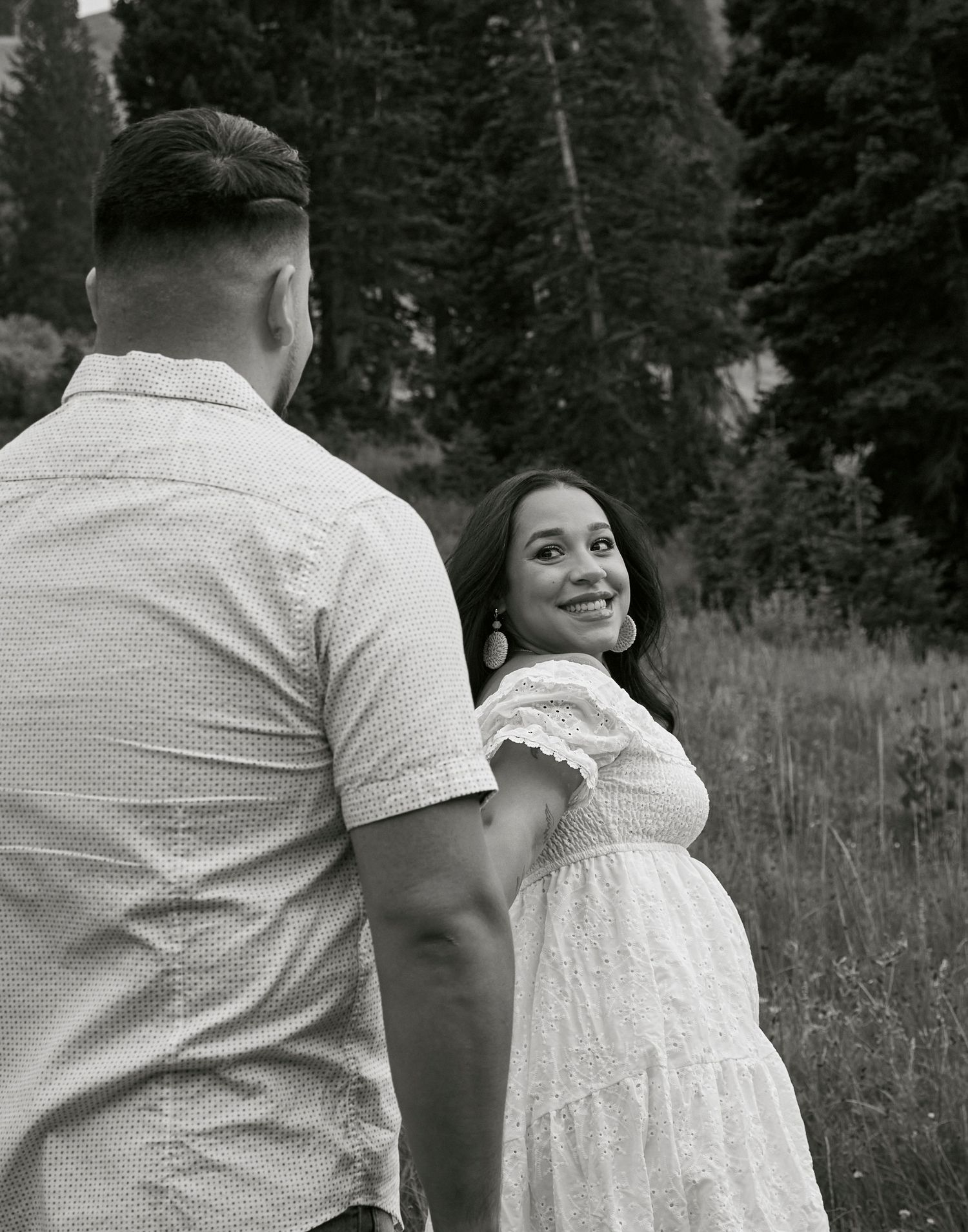 A black and white romantic couples portrait in a mountain setting showing genuine emotion.