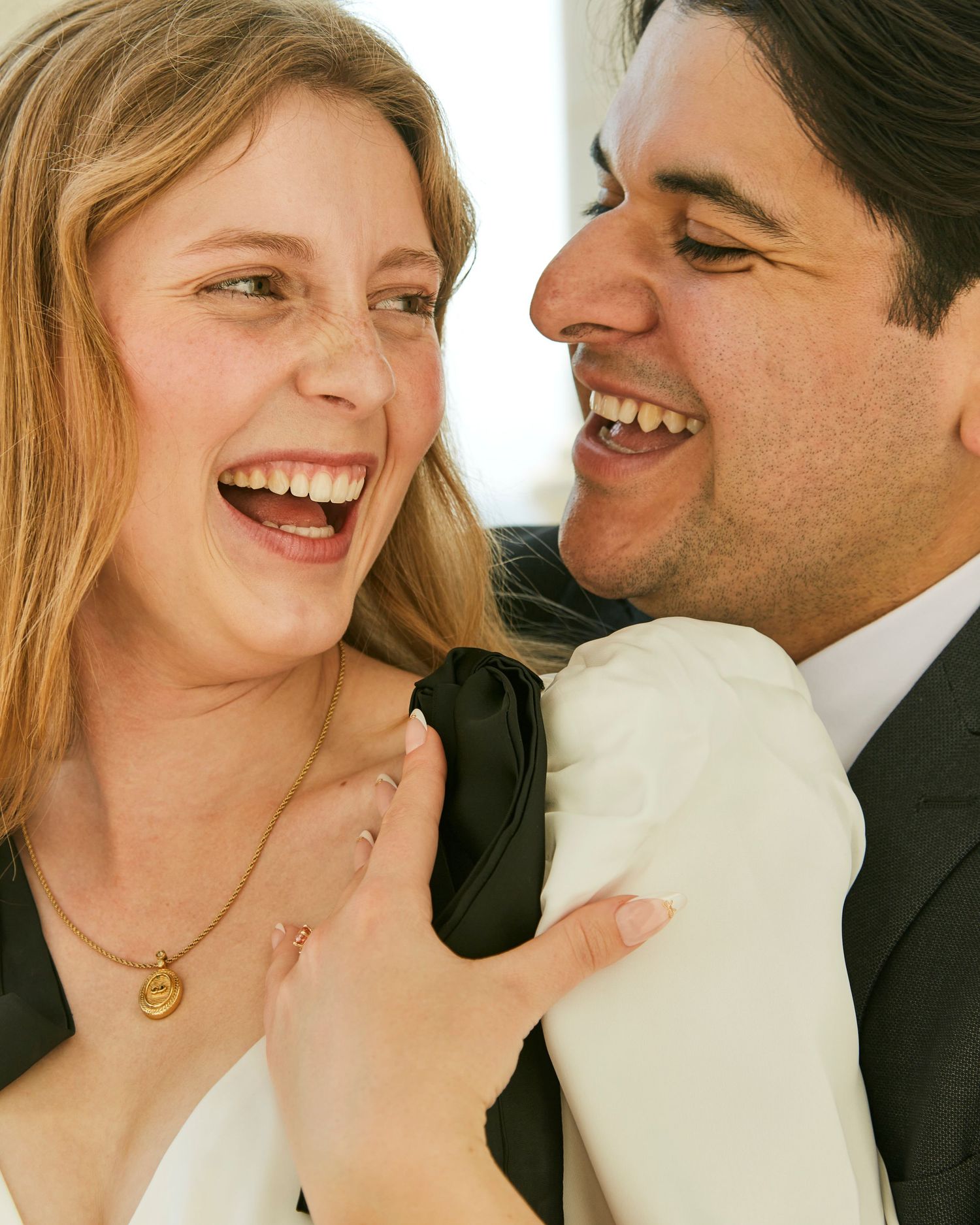 A joyful candid moment shared between a couple in formal attire.
