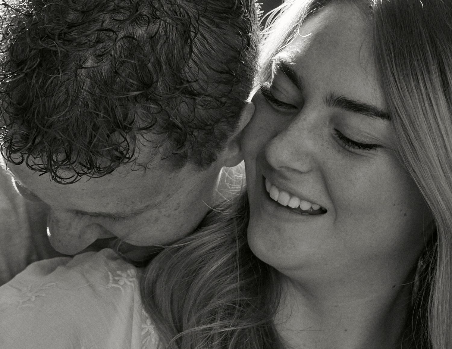 An intimate black and white close-up of a tender moment between two people.