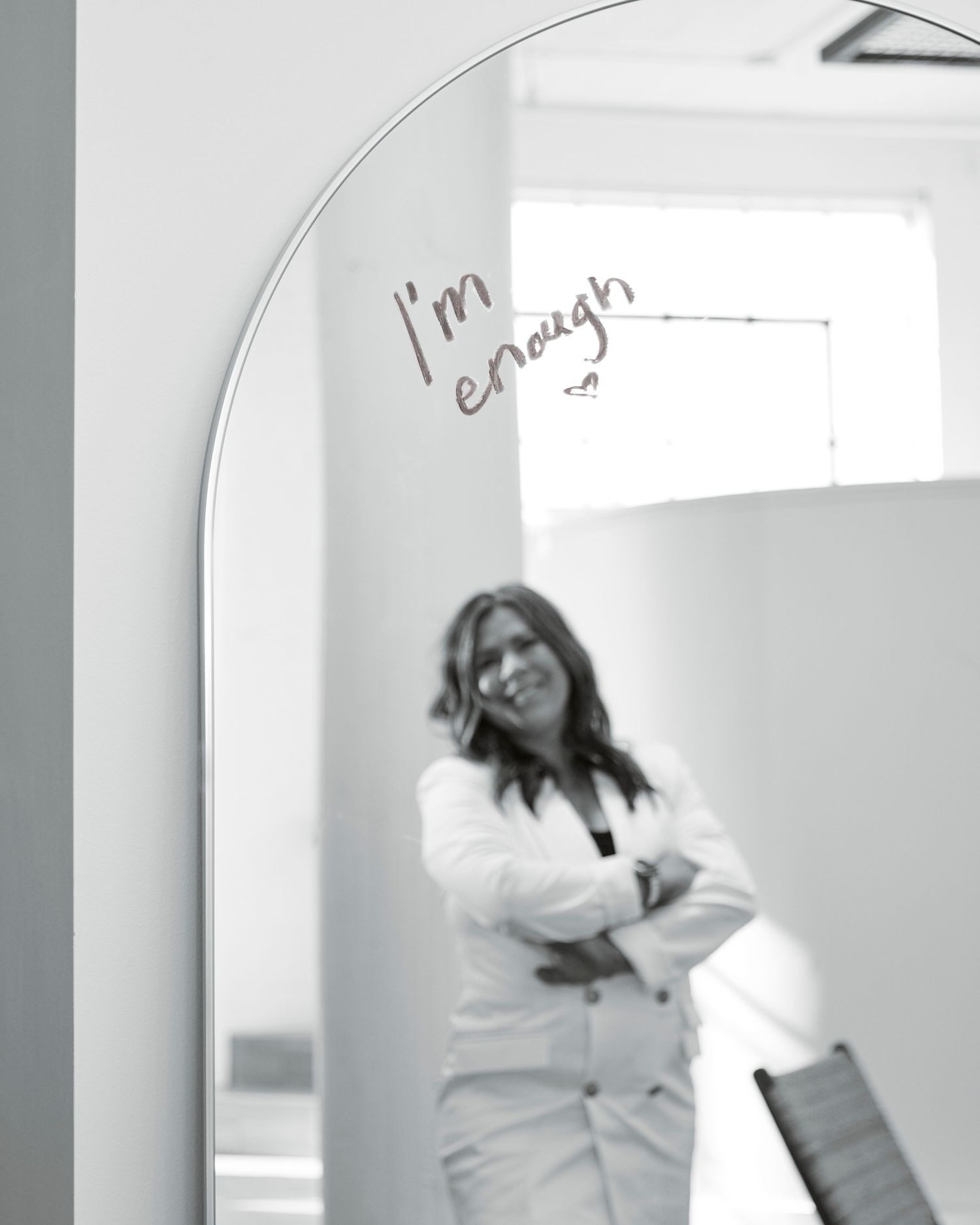 Black and white mirror reflection with 'I'm enough' text written on the glass.