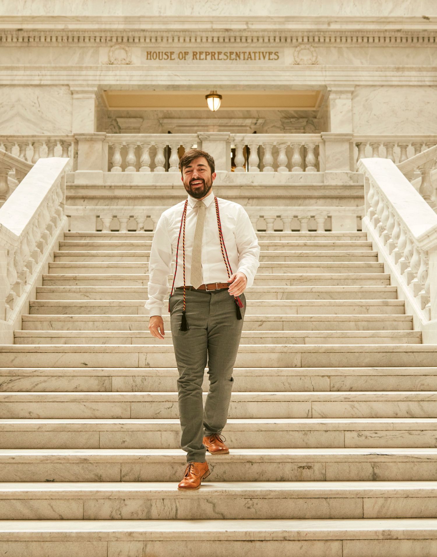 Person in business casual attire poses on House of Representatives steps.