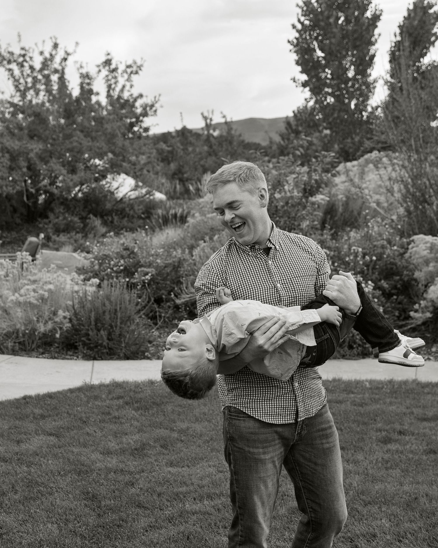 Black and white photo of joyful moment on garden lawn.