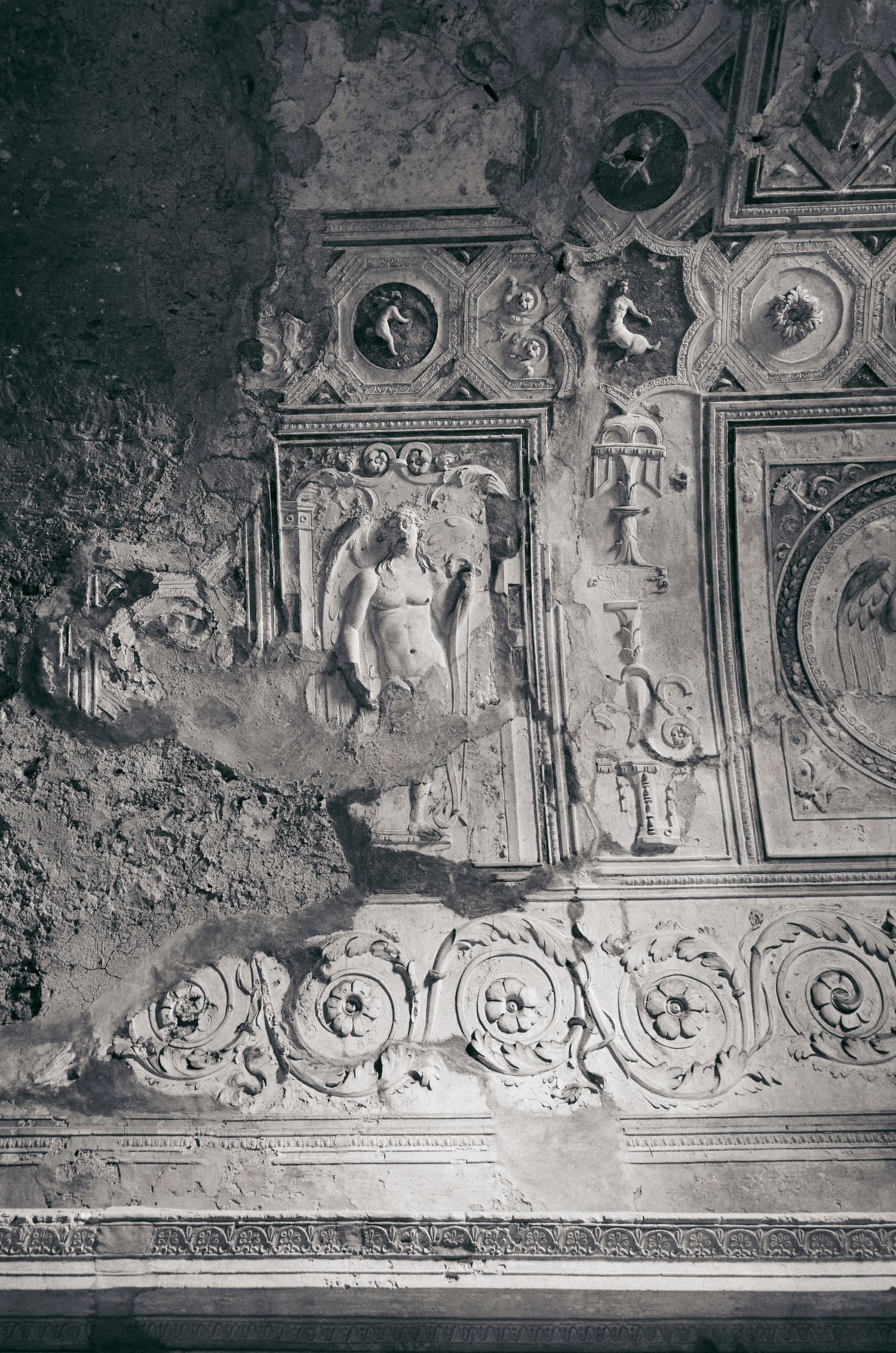Ornate baroque ceiling decorations with cherubs and religious motifs in black and white.