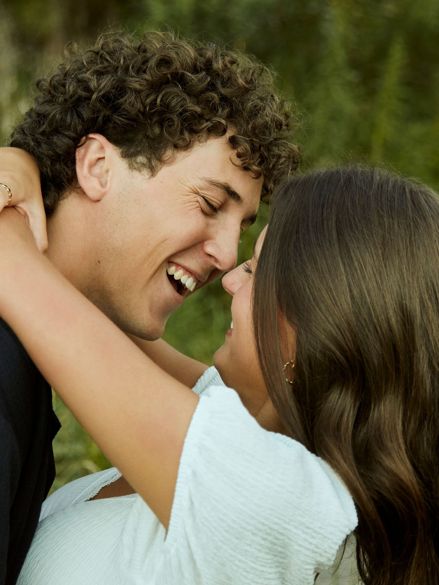 Intimate moment shared between a couple outdoors with natural lighting.