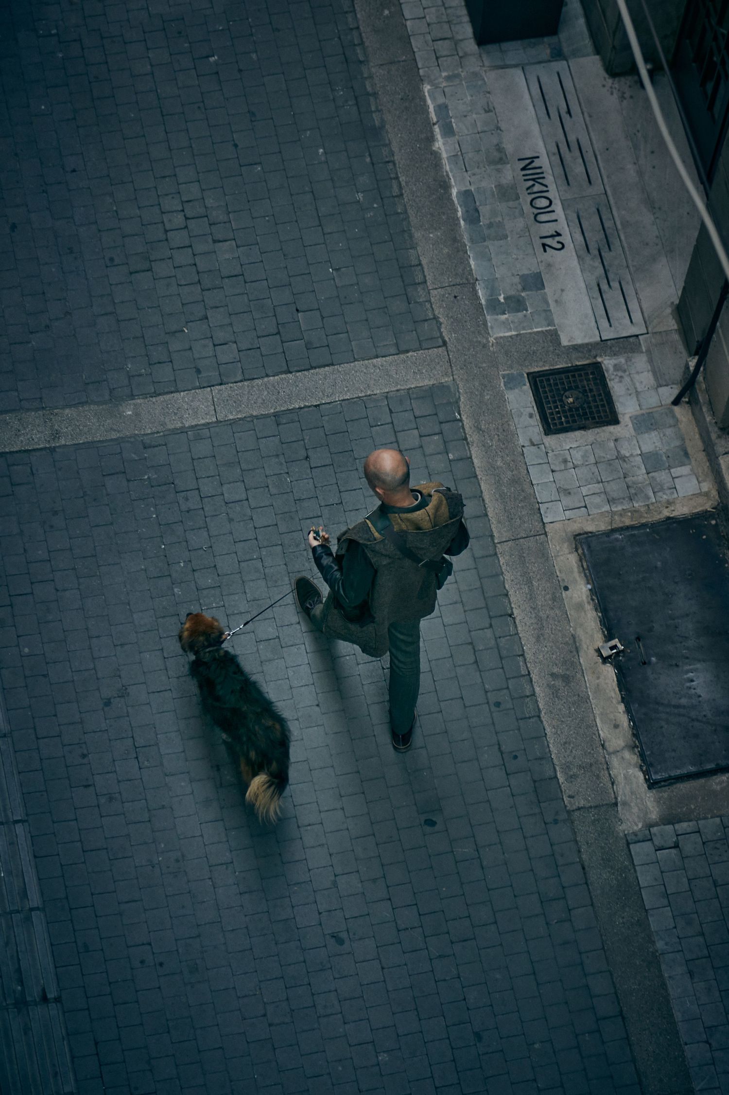 High angle view of people walking on a patterned cobblestone street.