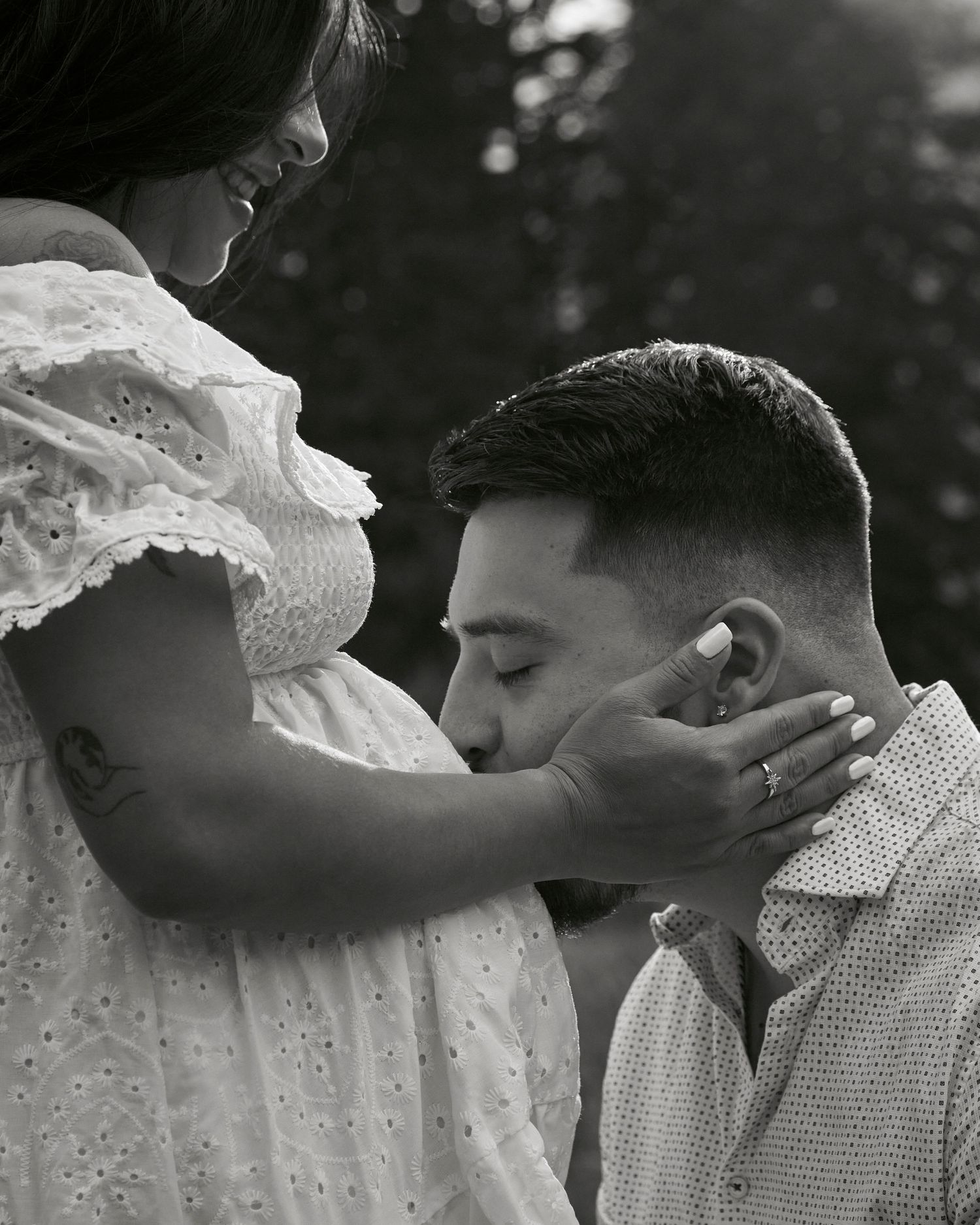 A tender moment captured in black and white as a couple shares an intimate embrace in a white lace dress and shirt.