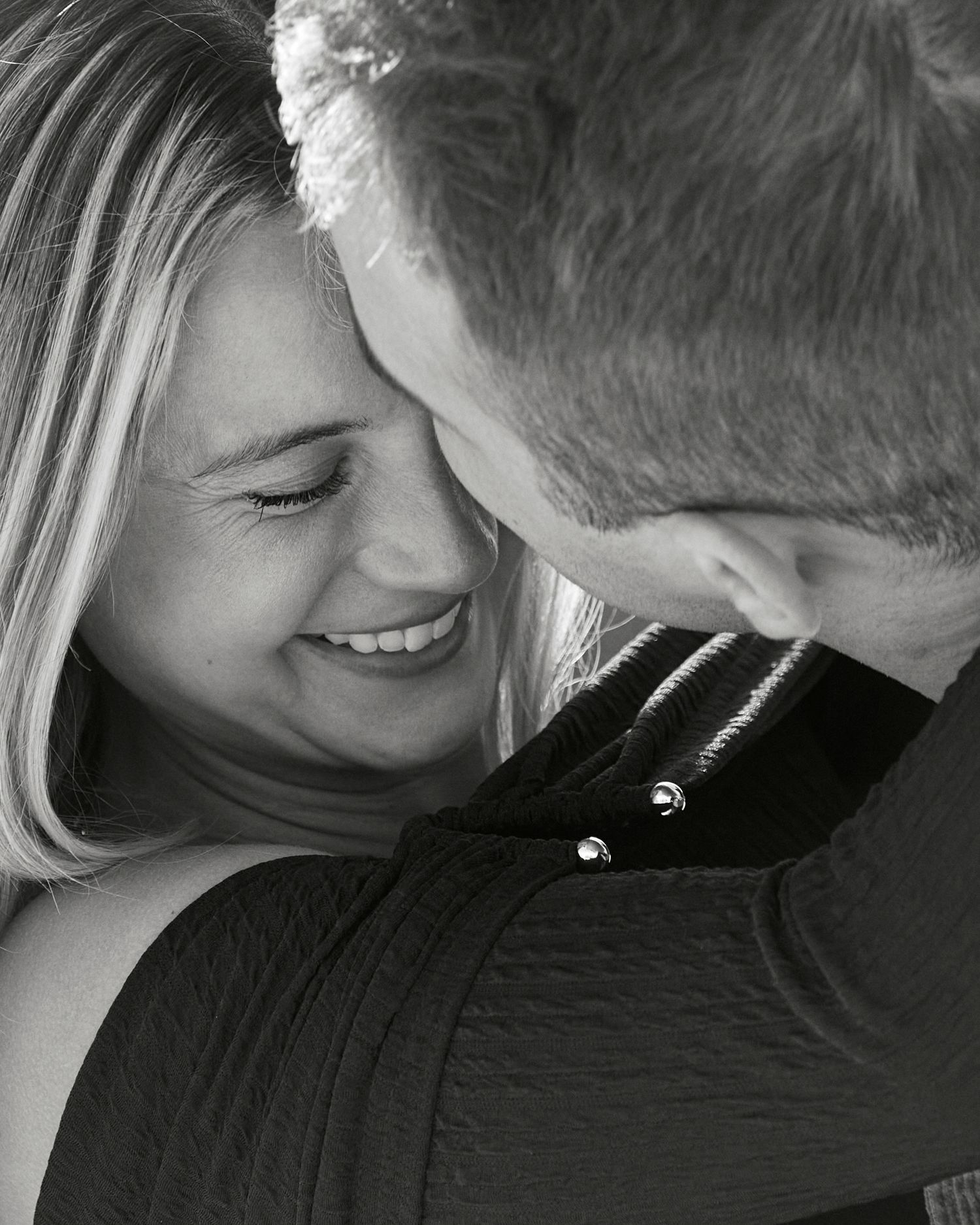 Intimate black and white portrait of couple sharing a tender moment together.