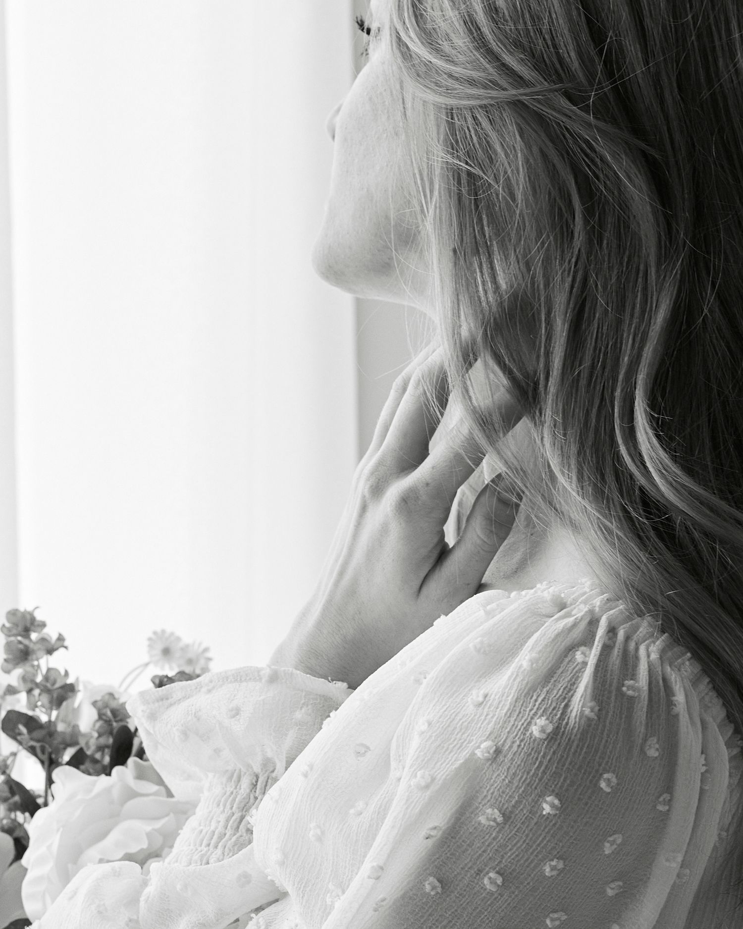 Dreamy black and white portrait detail with lace sleeve and soft window light.