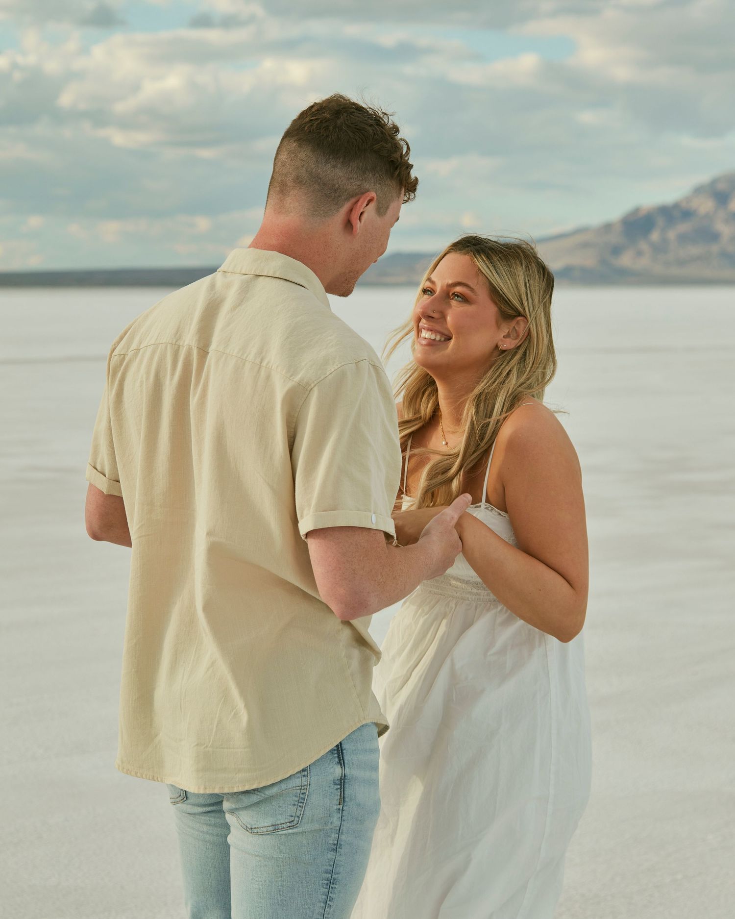 A candid moment of pure joy captured between couple after proposal on salt flats.