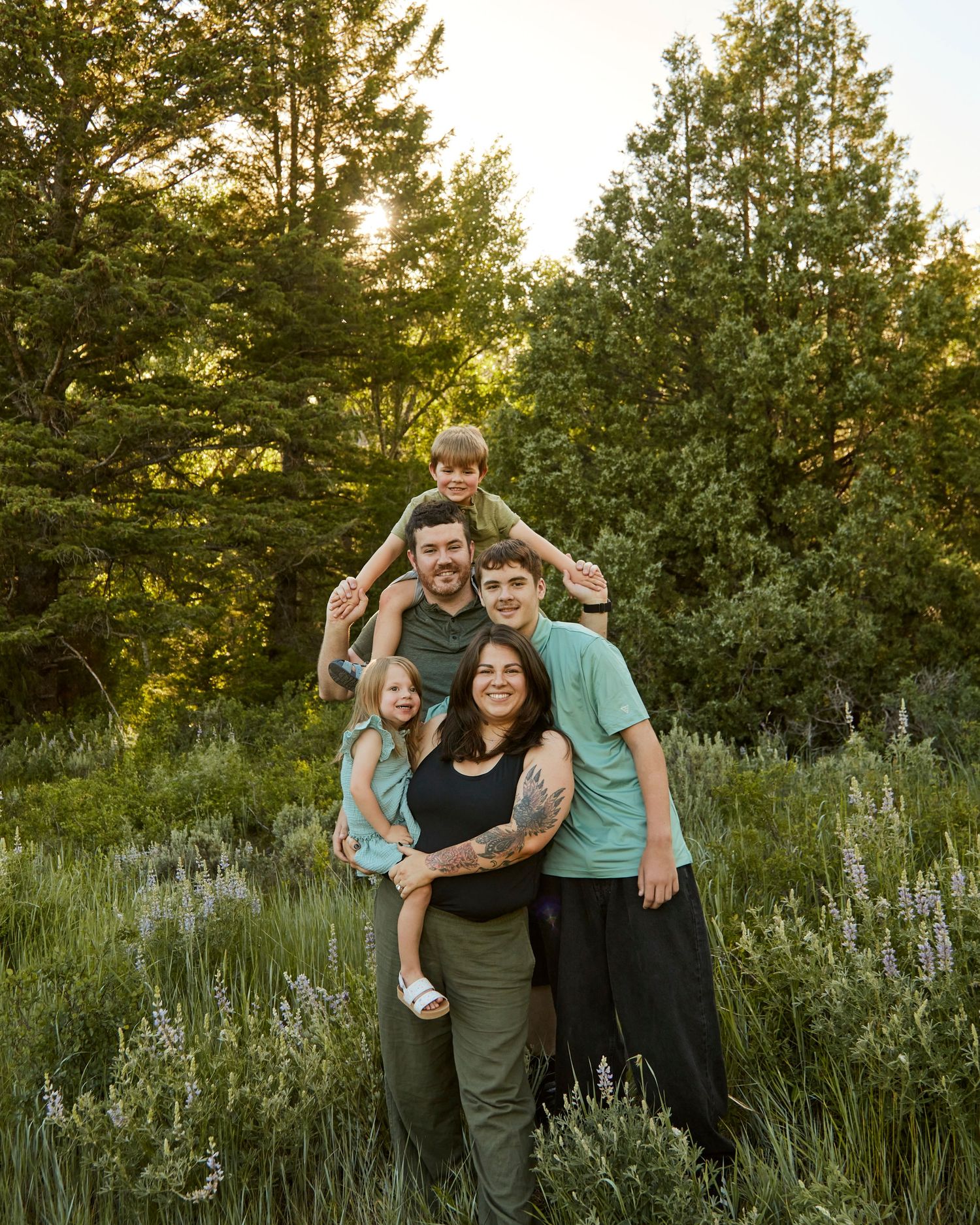 Family group photo in a mountain meadow with wildflowers at sunset.