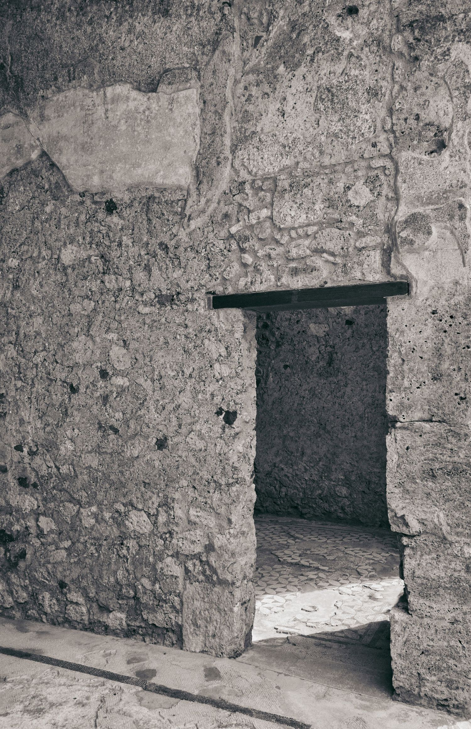 Stone doorway with weathered walls in an ancient structure captured in black and white.